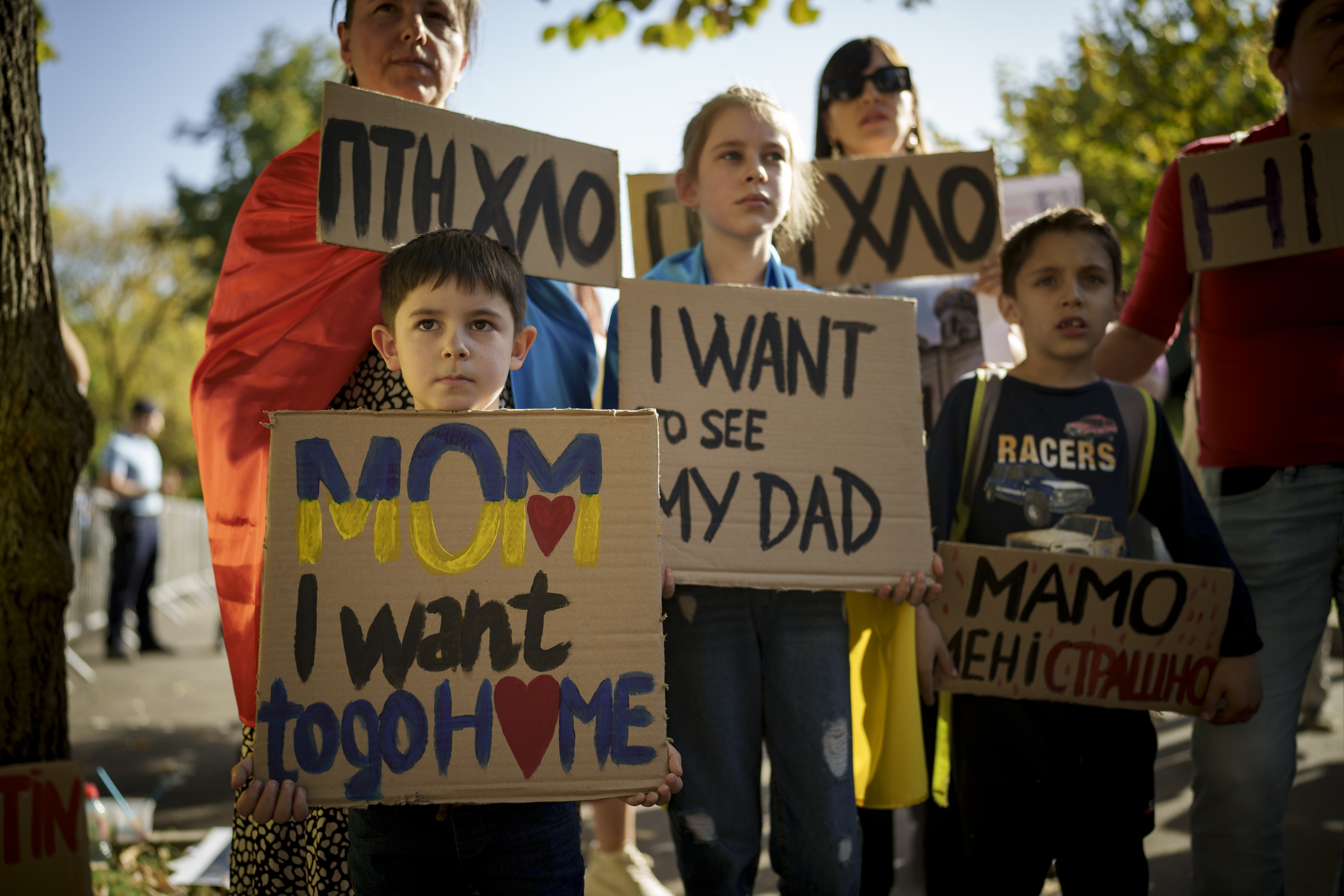 Ukrainians hold a protest outside the Russian Embassy in Bucharest. They are holding placards reading 'I want to go home' and 'I want to see my dad'