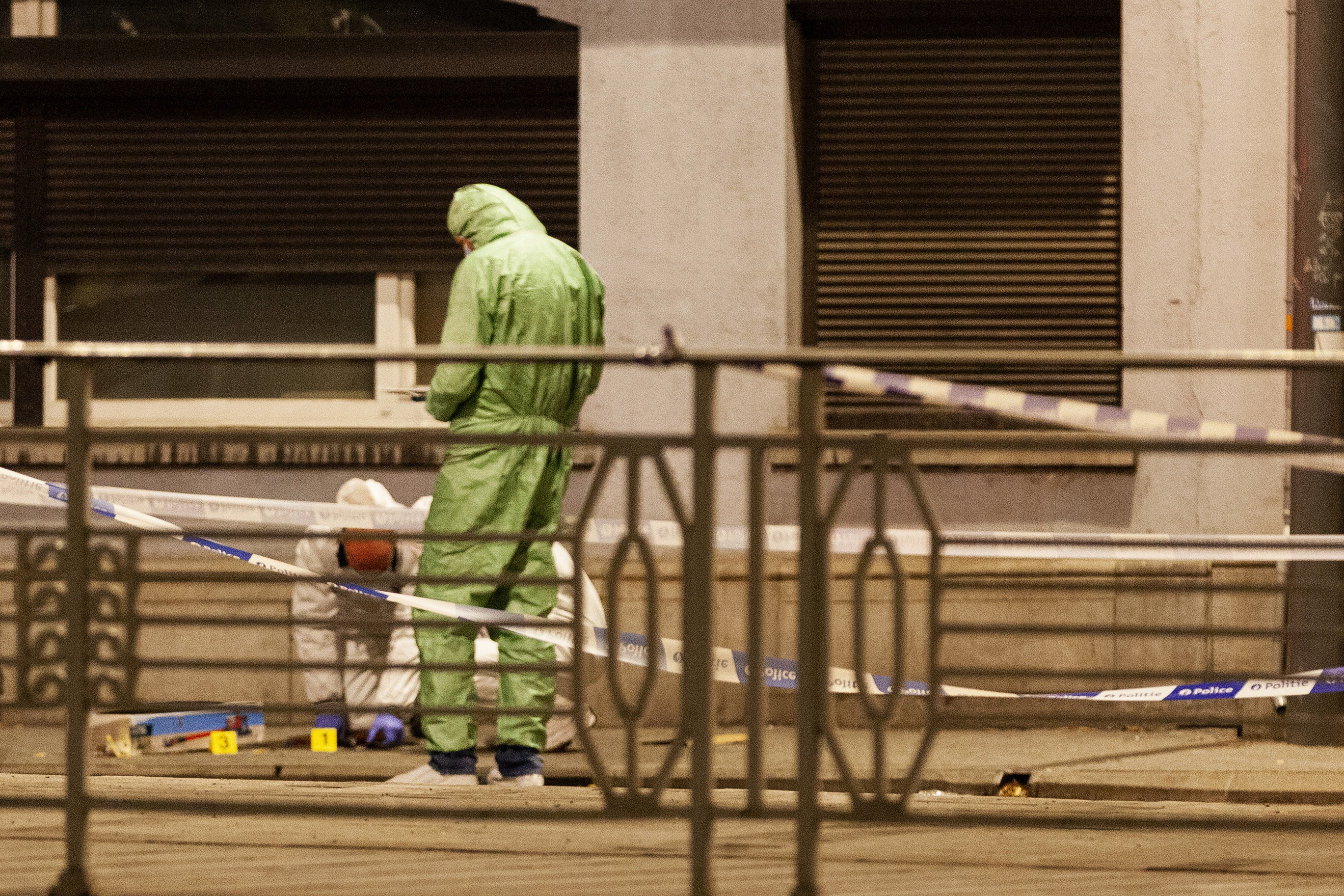Police and forensic teams at the site of the Brussels shooting. The area is corndoned off. The officers are in protective suits.
