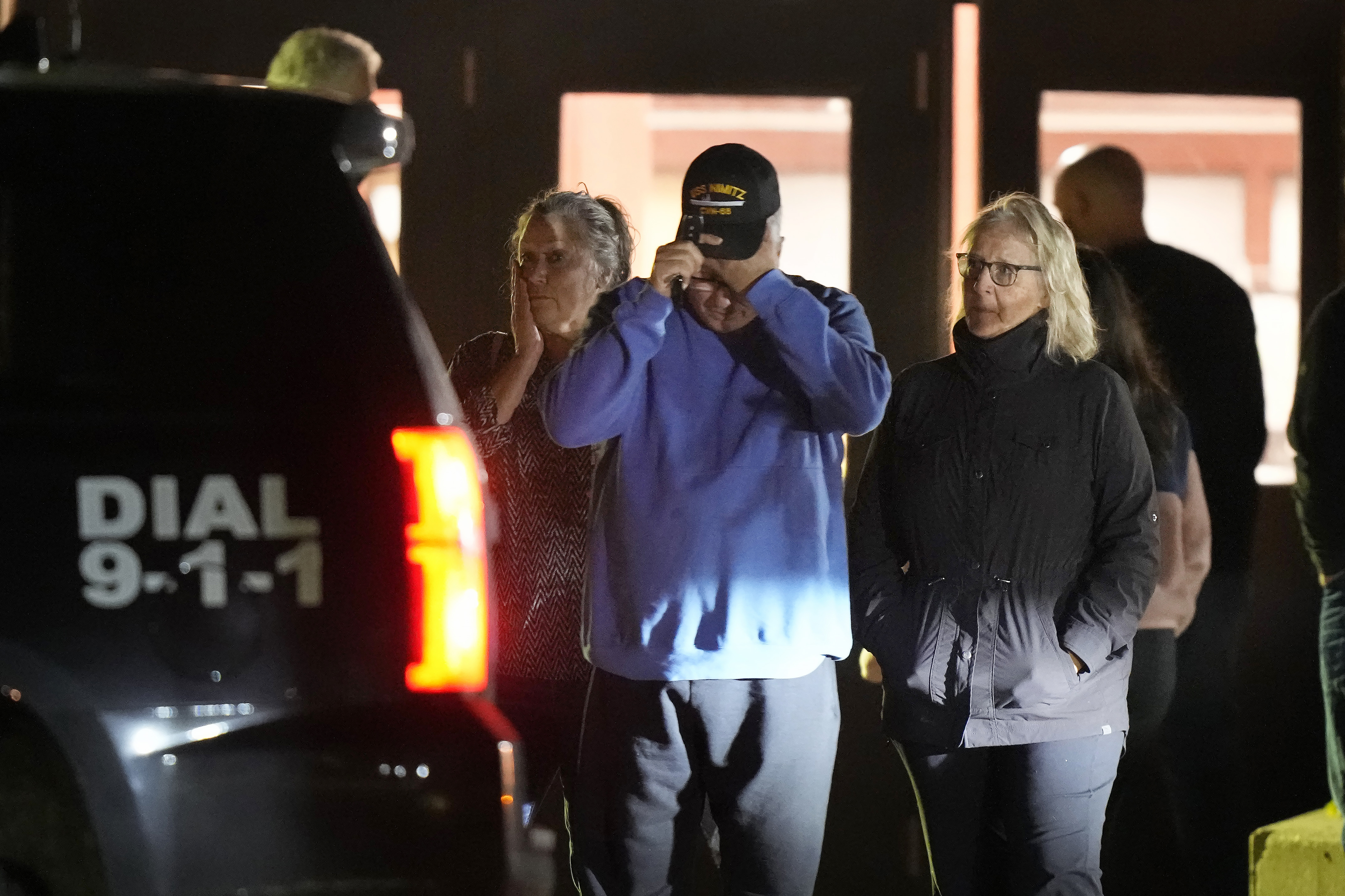 People depart a reunification center early Thursday, Oct. 26, 2023, at Auburn Middle School, in Auburn, Maine, after shootings in Lewiston