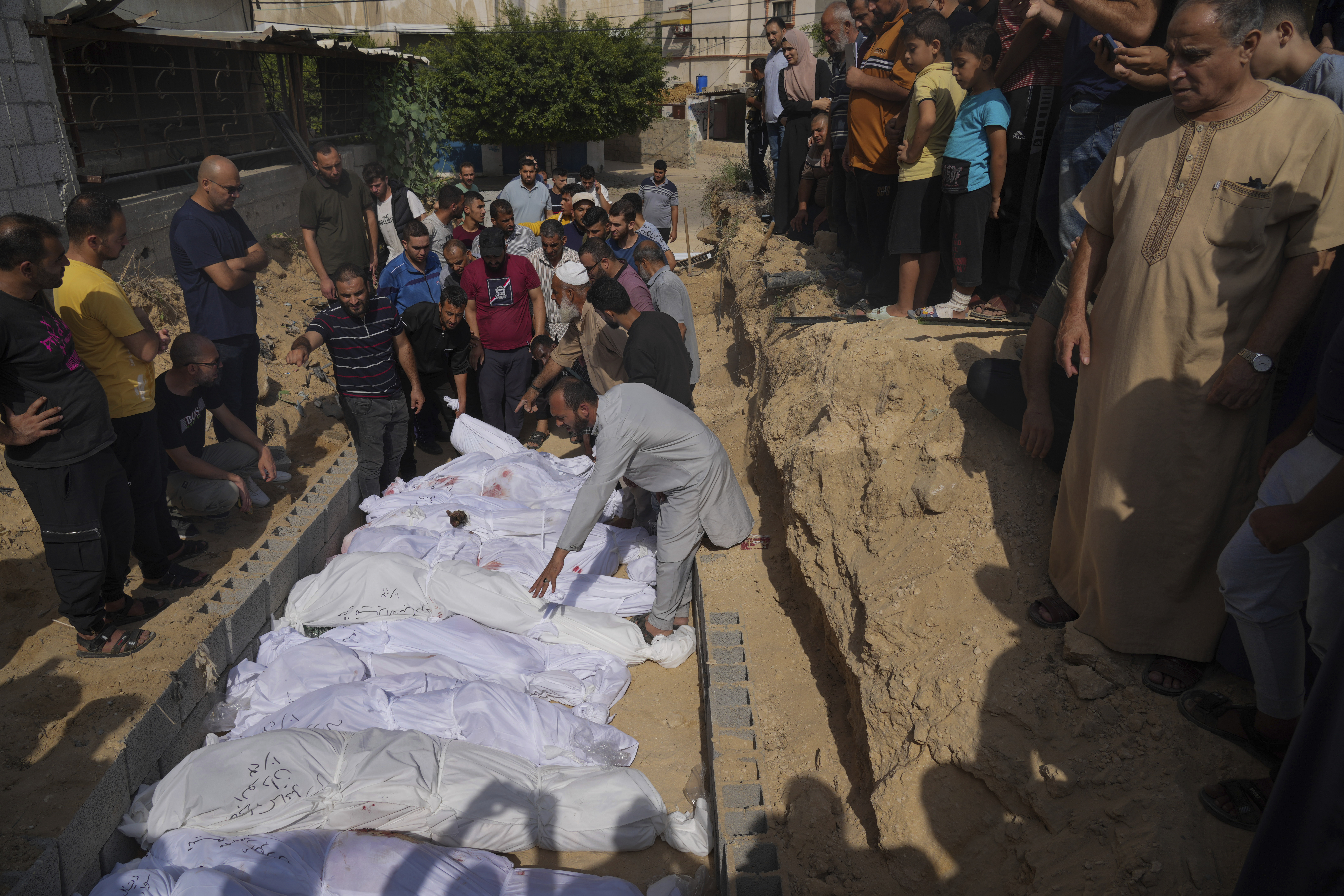 Palestinians bury the bodies of their relatives, killed in the Israeli bombardment of the Gaza Strip, Monday, Oct. 23