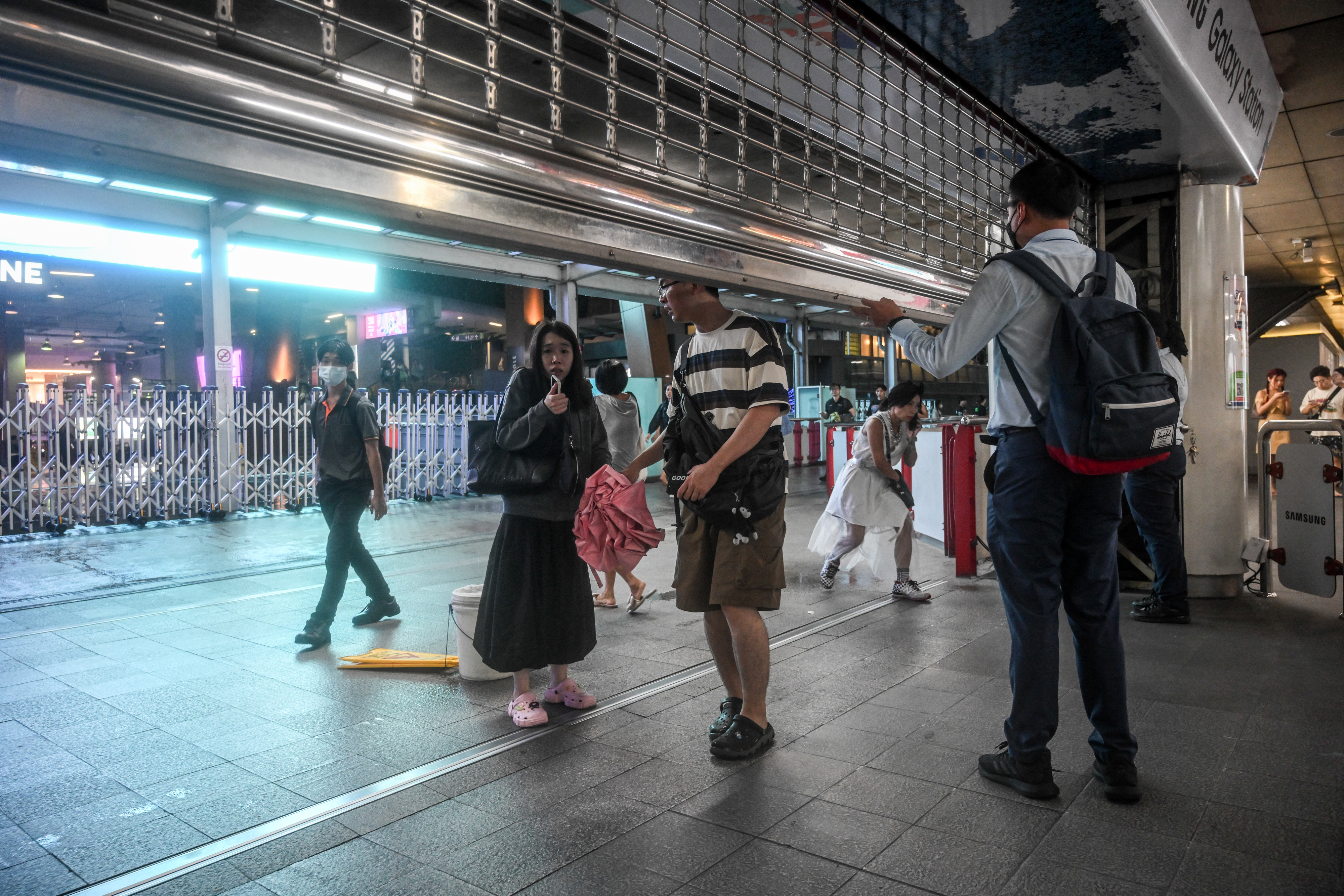 People exit the Siam Paragon mall as a shooting incident was still ongoing inside on October 03, 2023 in Bangkok, Thailand. A man opened fire insi