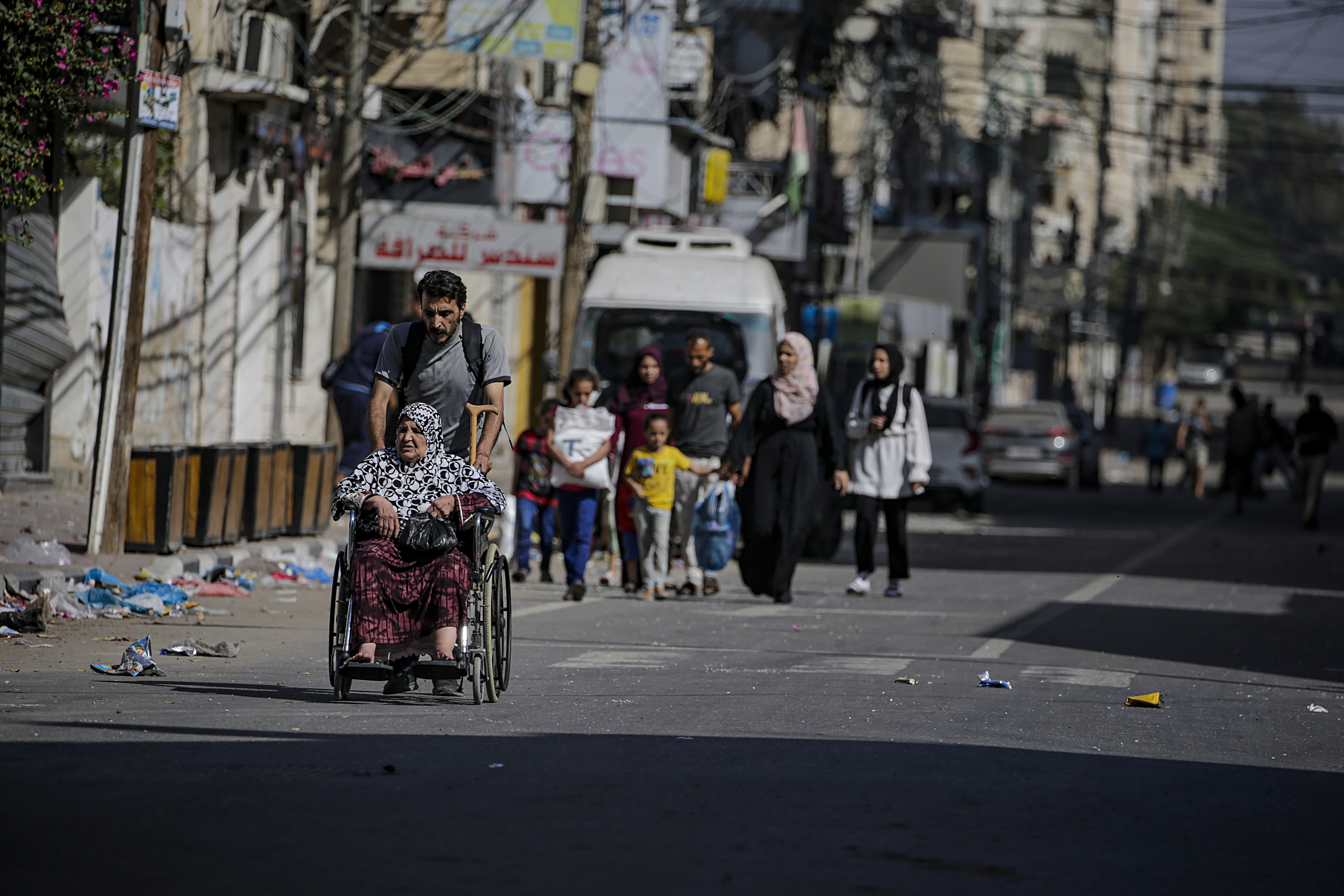 A man pushes an elderly woman on a wheelchair as residents evacuate Gaza City amid increased military operations in the Gaza Strip.