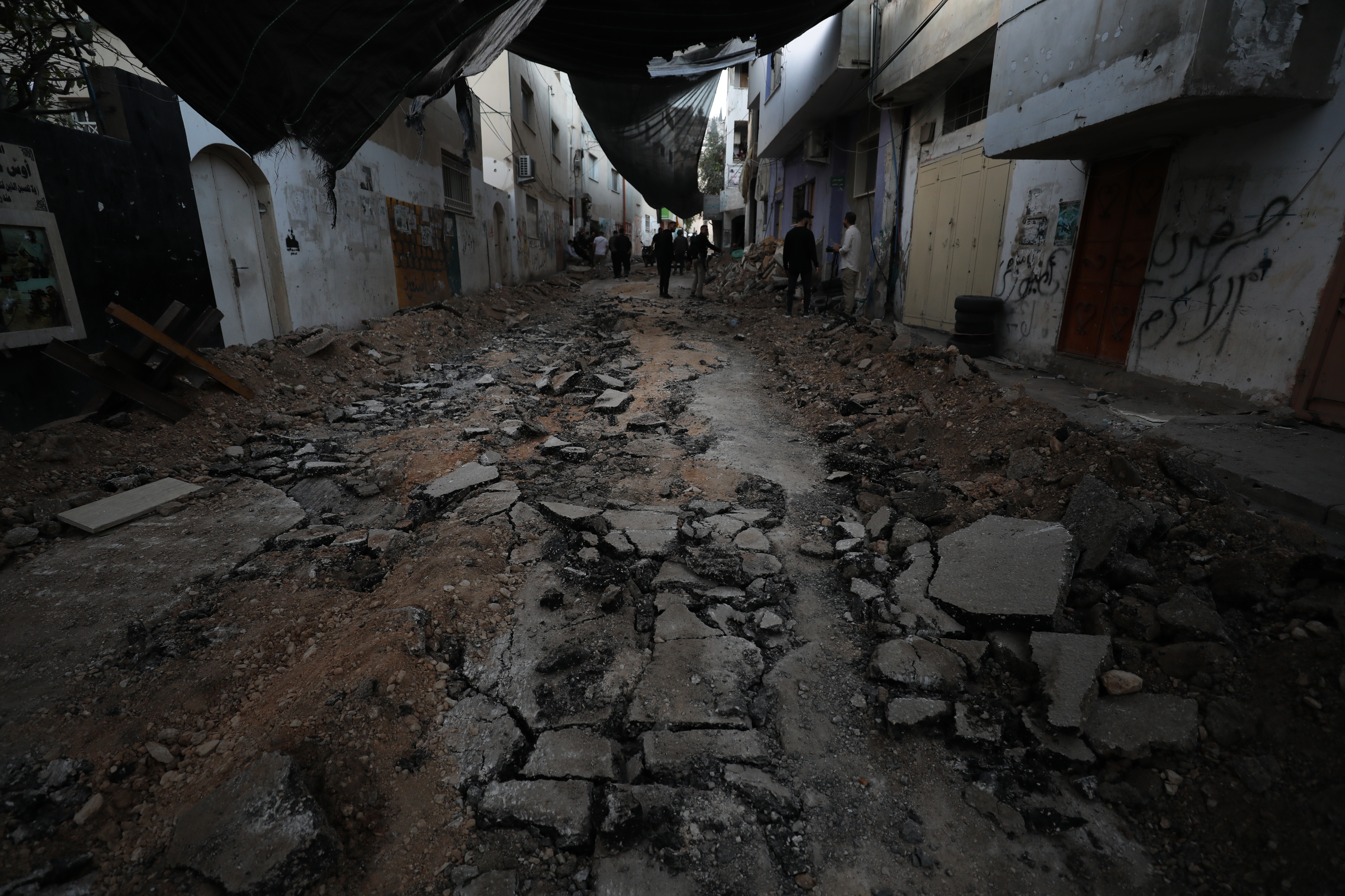 Palestinians inspect a damaged area inside the Jenin refugee camp following an Israeli raid, in the West Bank city of Jenin.