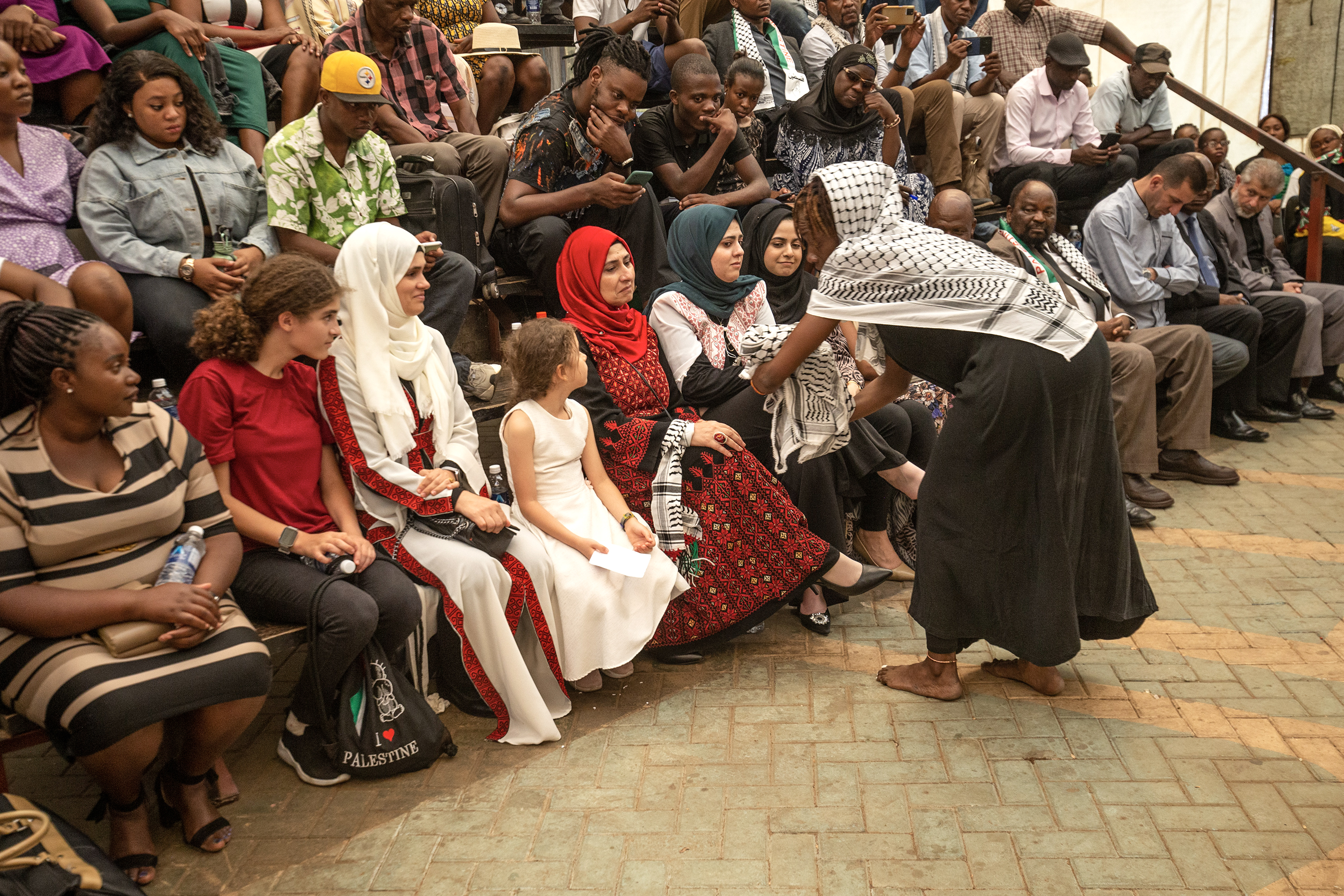 People sit as they watch a play on the ongoing situation in Gaza at the Theater in the Park, during the International Day of Solidarity with the Palestinian People, in Harare, Zimbabwe.
