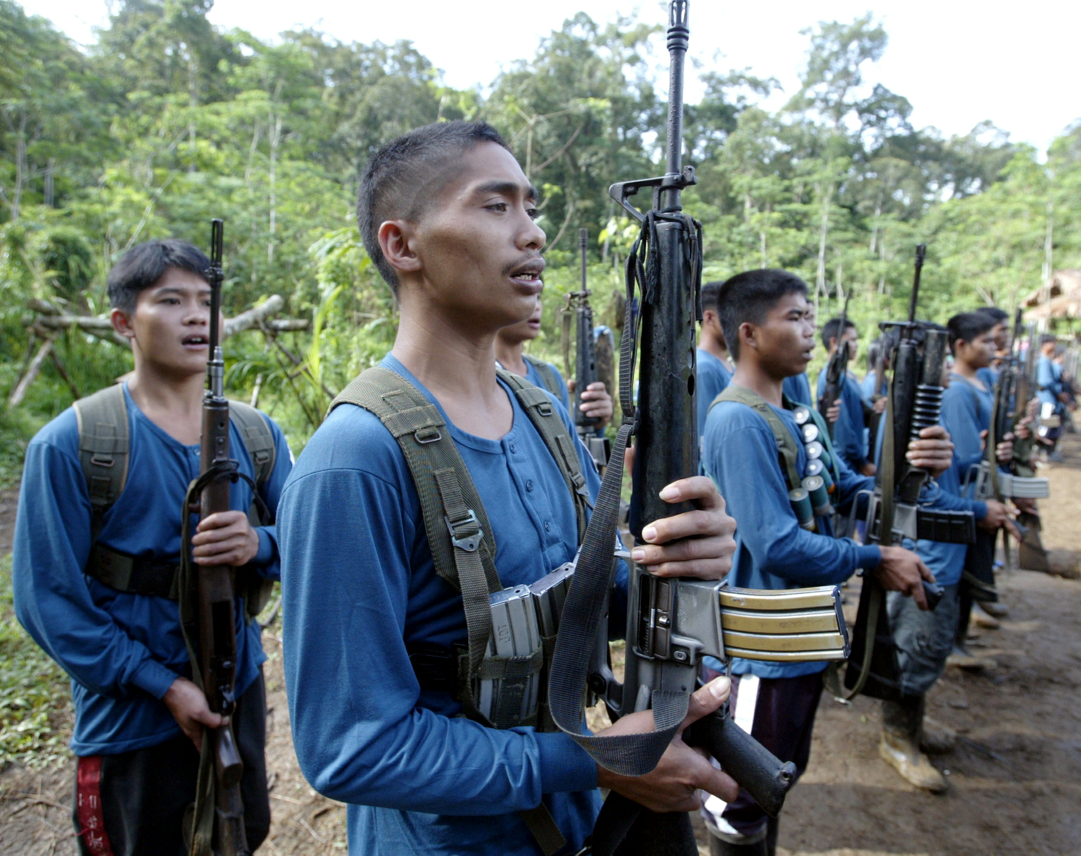 Members of the New Peoples Army (NPA), armed group of the Communist Party of the Philippines, sing "Internationale" during graduation after their military training in their jungle hideout in Lianga on southern Mindanao island March 13, 2004. Members of the world's oldest communist insurgency see little hope of peaceful change in the Philippines and have vowed to step up their rebellion with the help of weapons obtained from the military. Photo taken March 13.