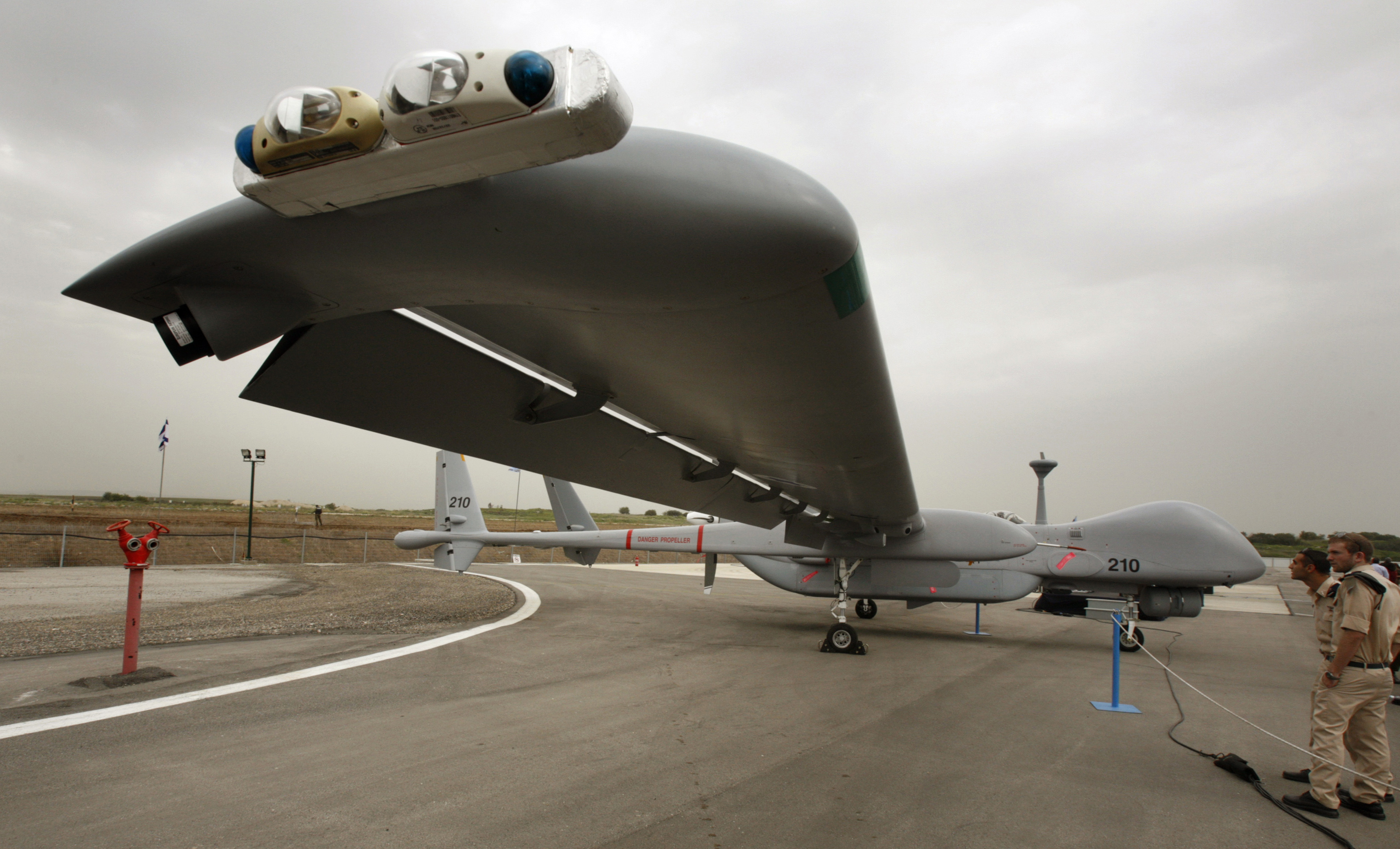 Israeli soldiers look at an IAI Eitan, also known as the Heron TP, surveillance unmanned air vehicle (UAV) on display at Tel Nof Air Force Base near Tel Aviv