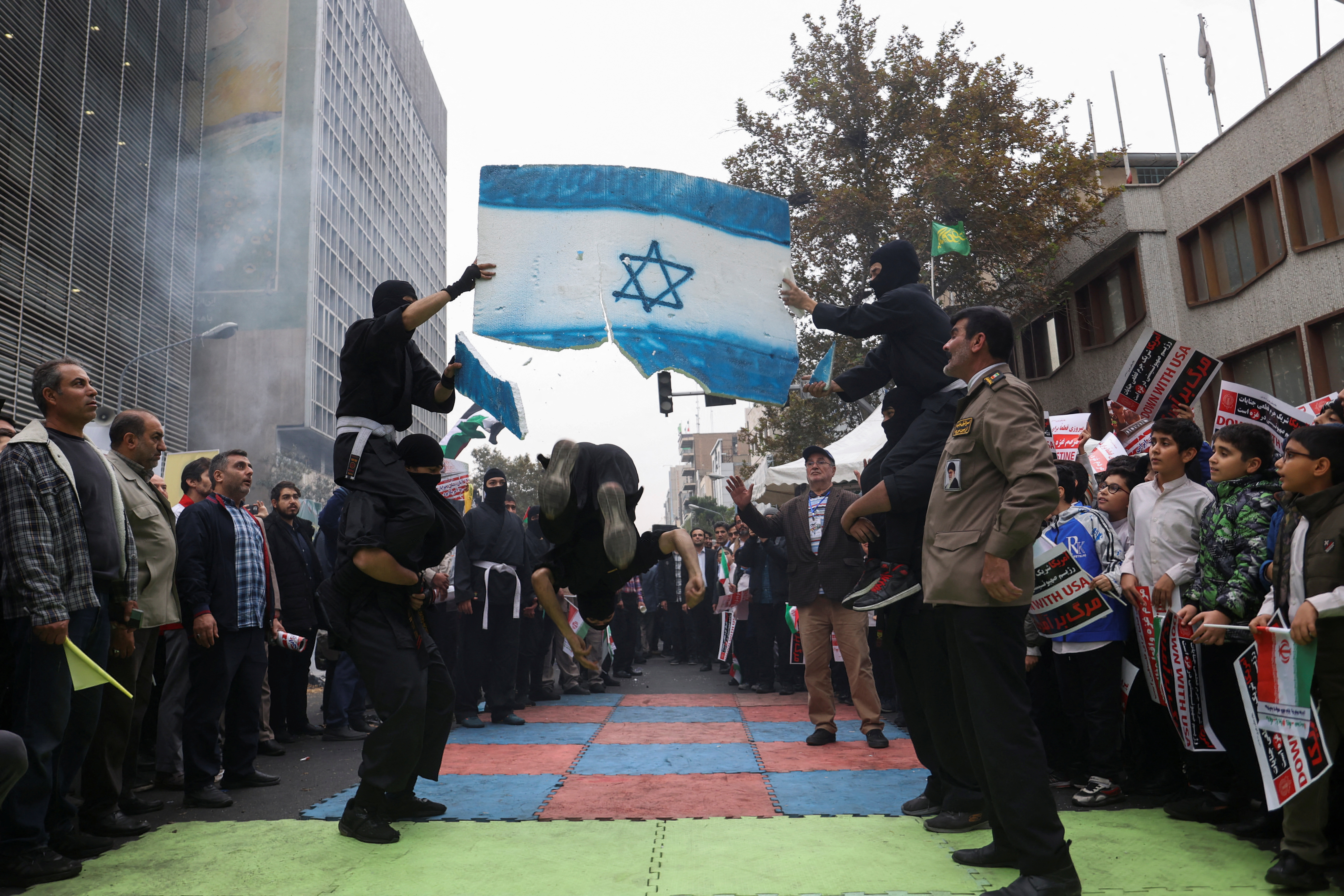 An Iranian man kicks a plastic Israeli flag during the 44th anniversary of the U.S. expulsion from Iran, in Tehran, Iran.
