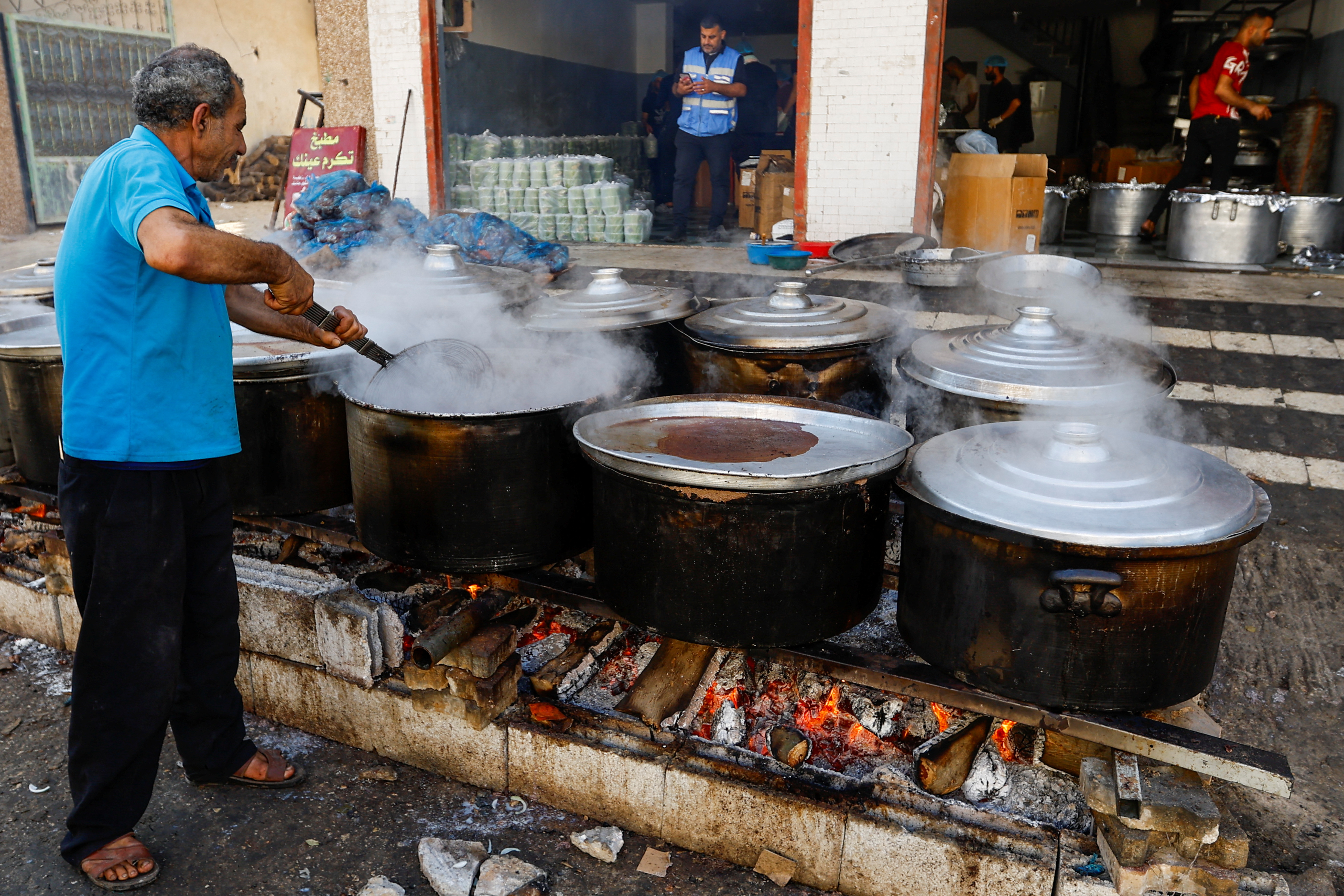 Palestinians cook on firewood, amid fuel and cooking gas shortages, as the conflict between Israel and Hamas continues, in Khan Younis in the southern Gaza Strip