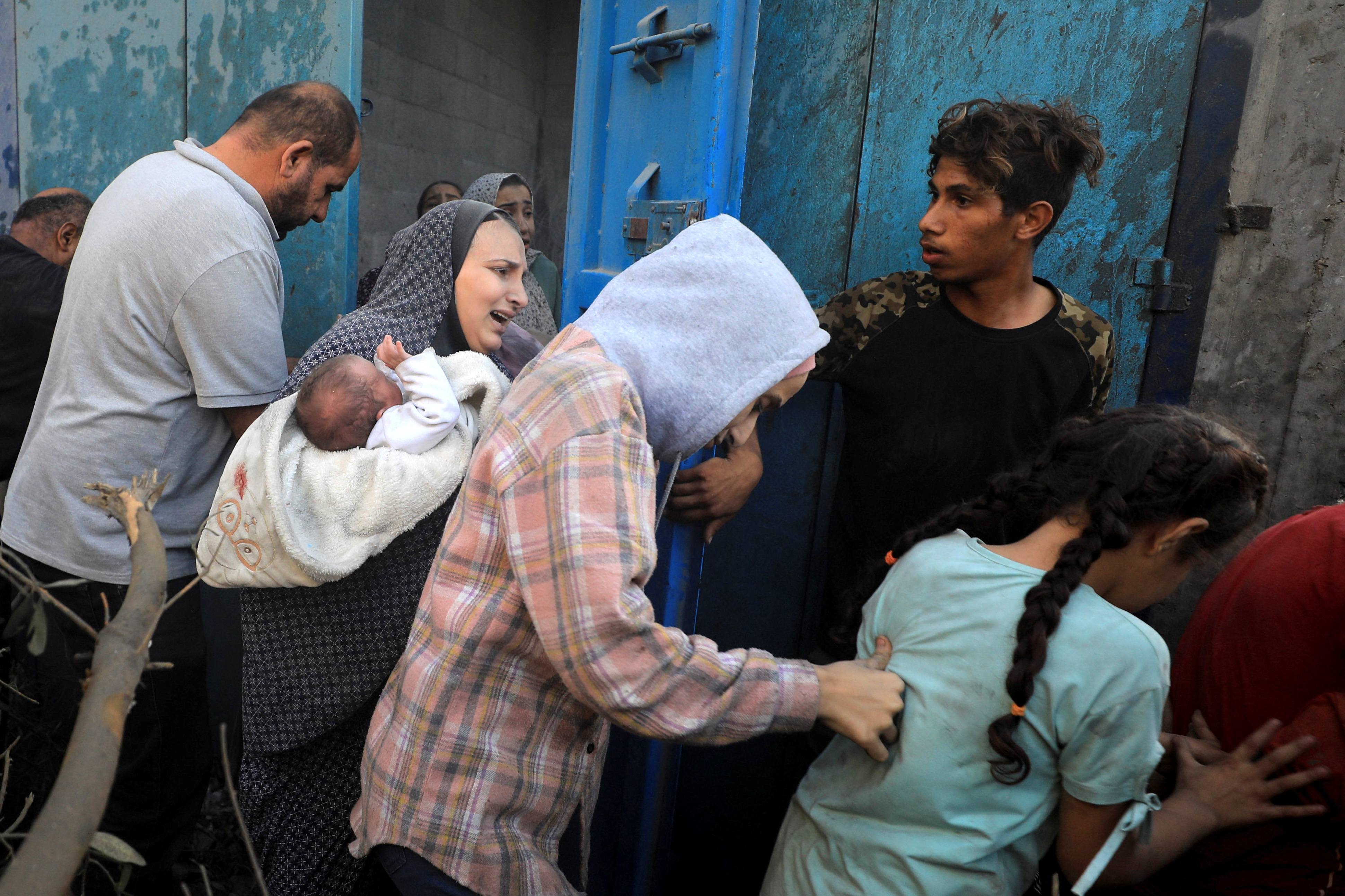 Palestinians evacuate the site of Israeli strikes on houses, amid the ongoing conflict between Israel and Palestinian Islamist group Hamas, in Maghazi refugee camp in the central Gaza Strip