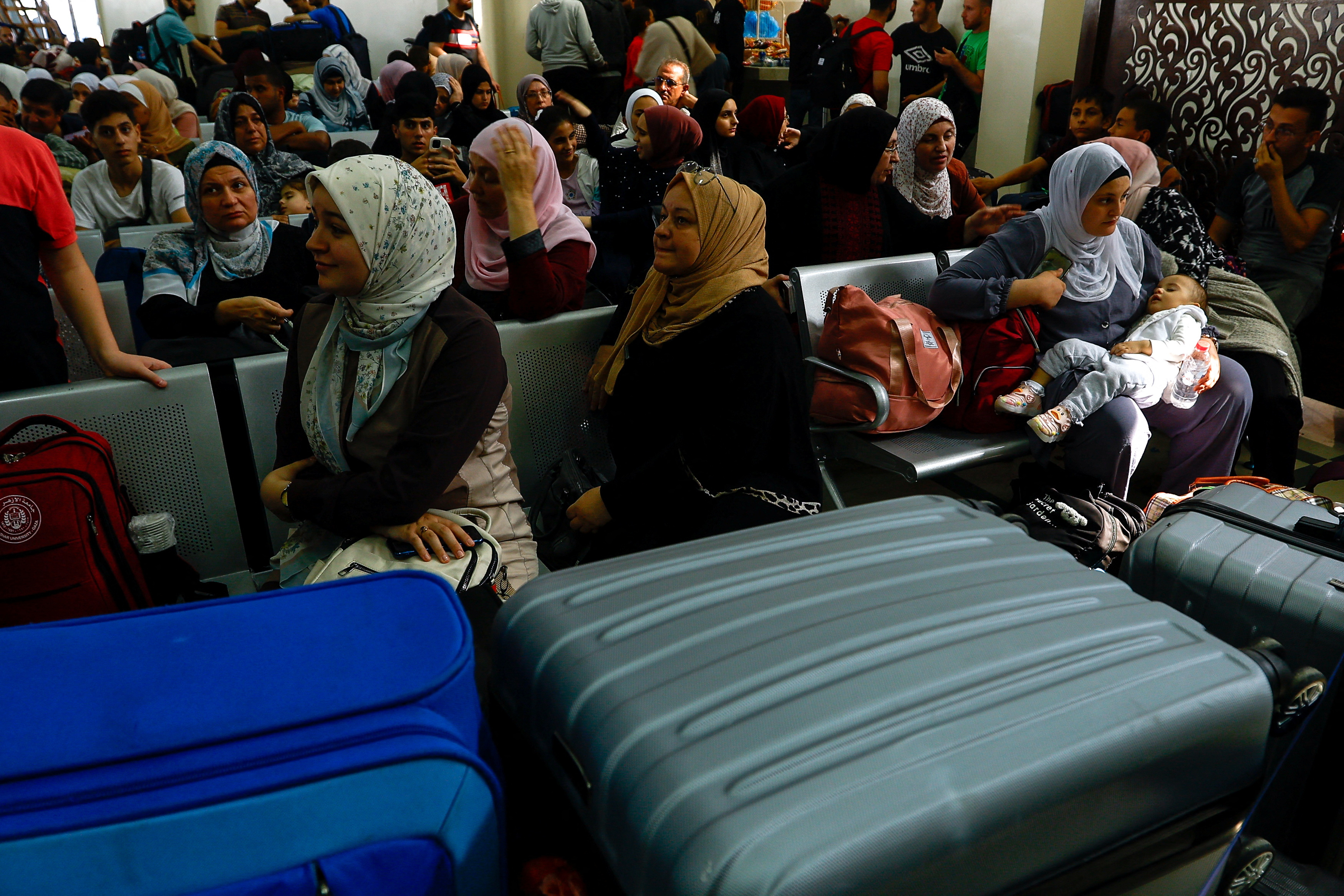 Palestinians with foreign passports wait for permission to leave Gaza at the Rafah border crossing with Egypt, in Rafah in the southern Gaza Strip, on November 7, 2023