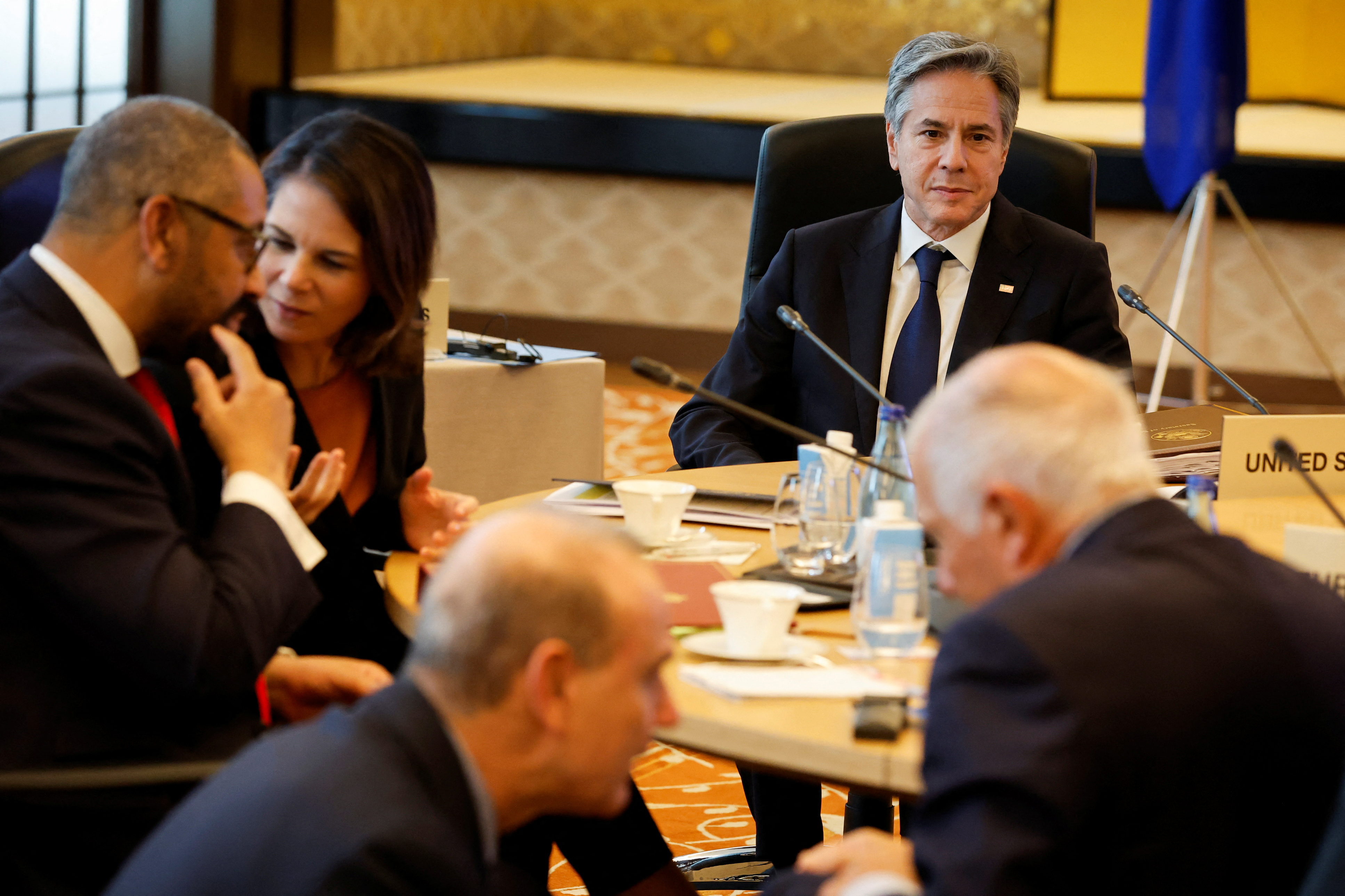 U.S. Secretary of State Antony Blinken looks on as British Foreign Secretary James Cleverly and German Foreign Minister Annalena Baerbock interact during a session in Tokyo