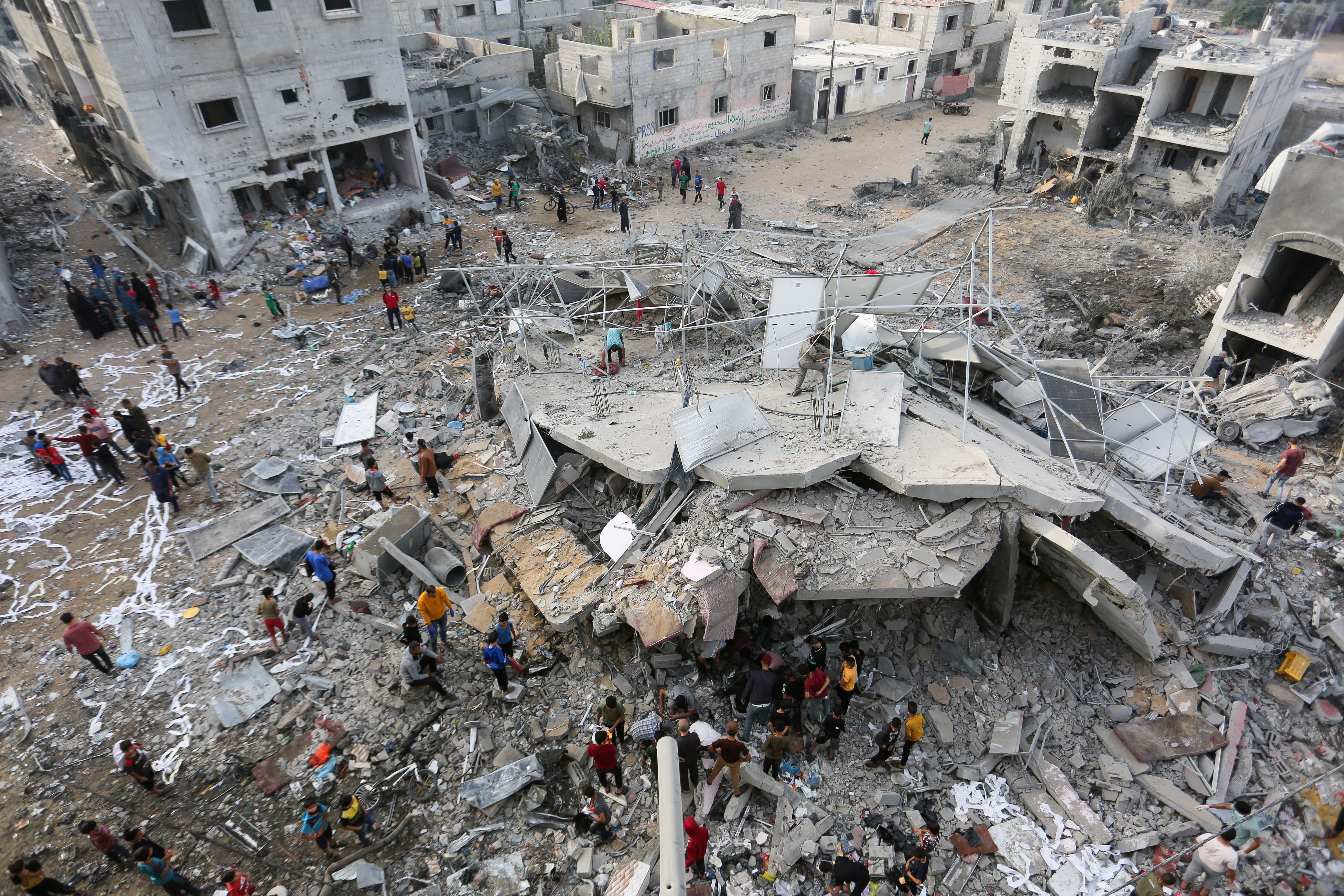 Palestinians search for casualties as they inspect the site of an Israeli strike on a house belonging to Fojo family in Rafah