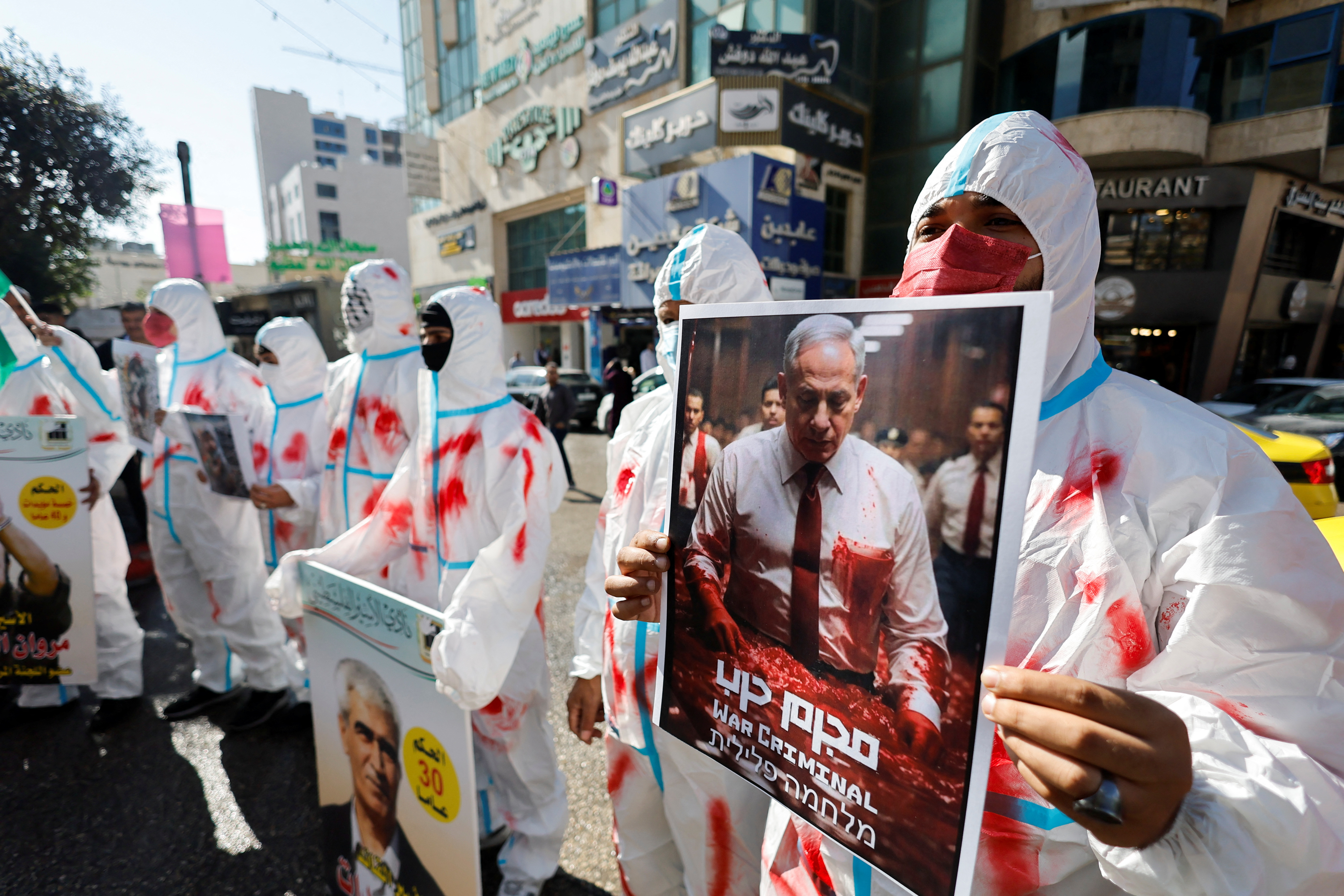 Protesters wear shrouds during a protest in solidarity with Gaza and Palestinian prisoners in the Israeli jails in Hebron