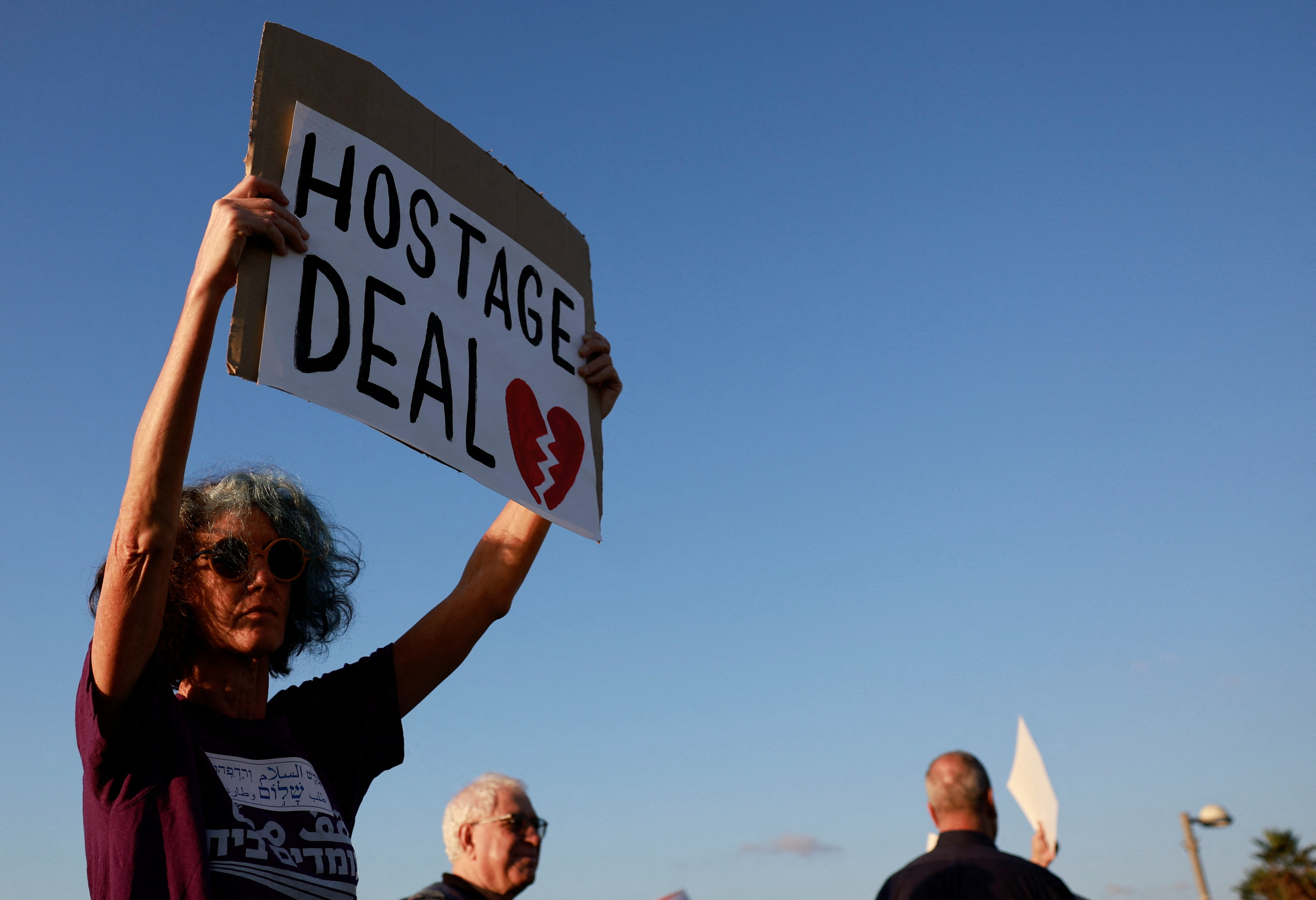 A protester holds a sign urging a captive release deal in Tel Aviv