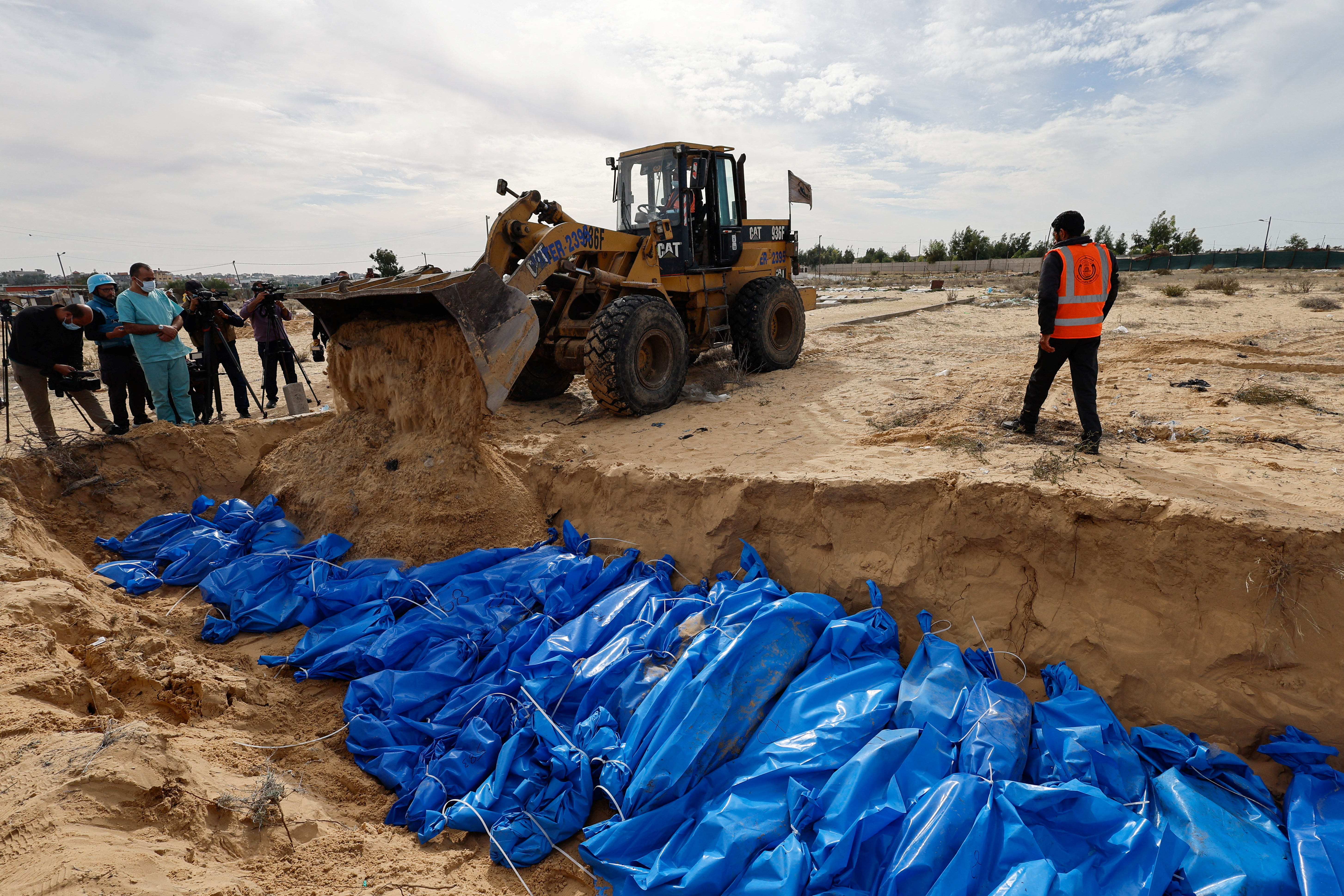 Palestinians killed in Israeli strikes are buried in a mass grave in Khan Younis