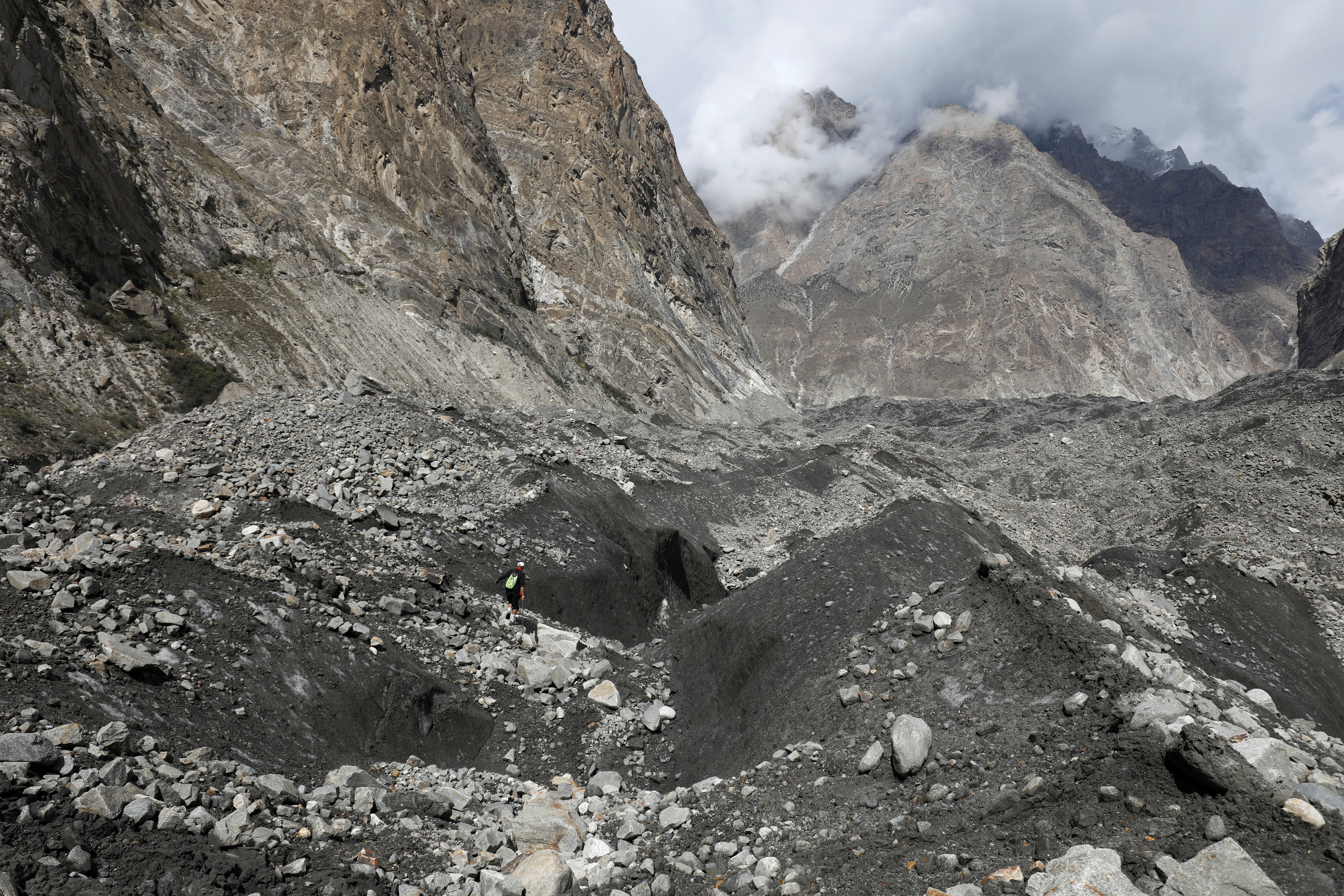 Tariq Jamil, 51, chairman of the Community Based Disaster Risk Management Centre, walks with a hiking stick to check the ice on the Shisper glacier, near Hassanabad village, Hunza valley, in the Karakoram mountain range in the Gilgit-Baltistan region of Pakistan.
