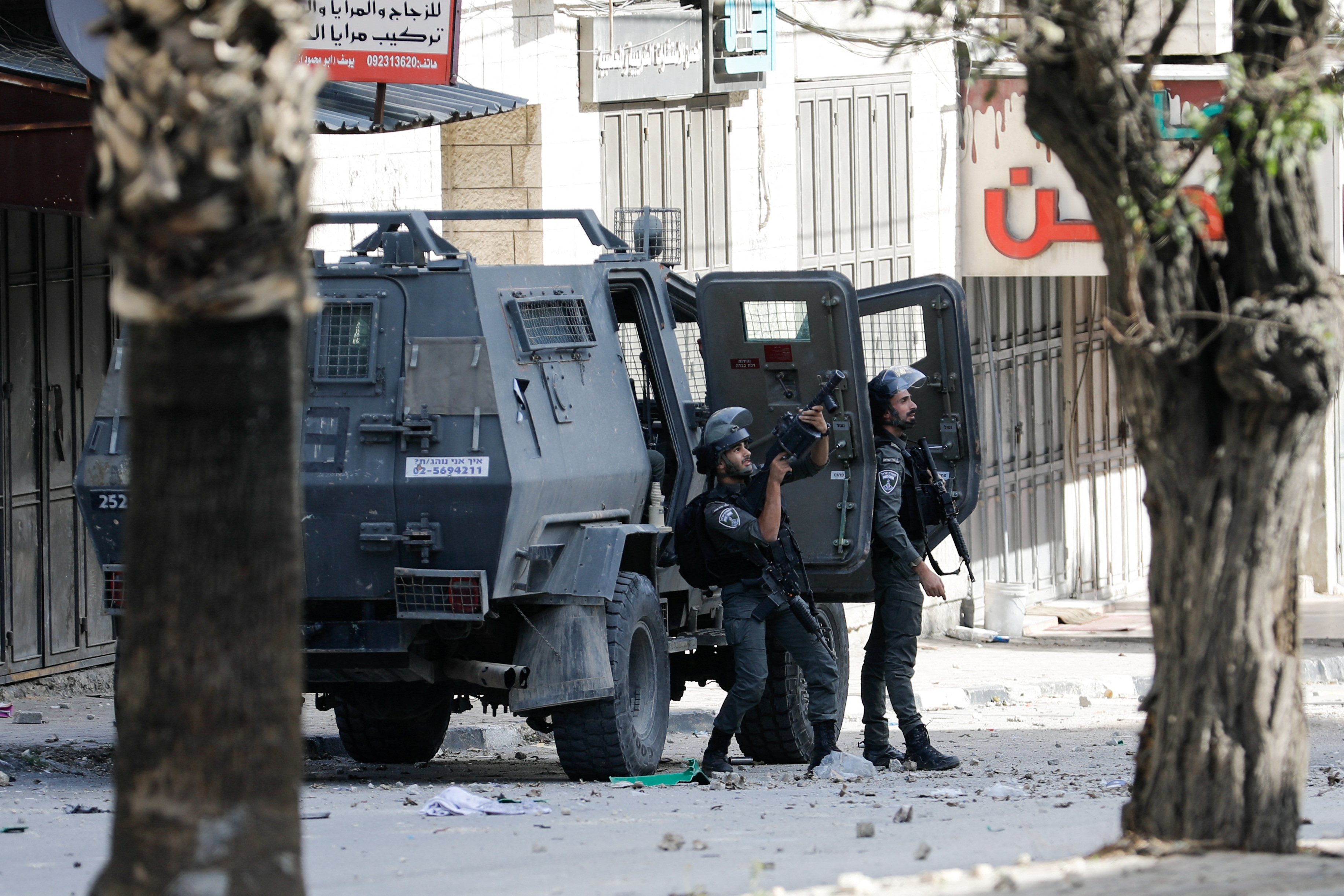 An Israeli soldier aims a weapon next to an Israeli army vehicle in the Balata refugee camp in Nablus, amid the ongoing conflict between Israel and the Palestinian Islamist group Hamas, in the Israeli-occupied West Bank November 23, 2023. REUTERS/Raneen Sawafta