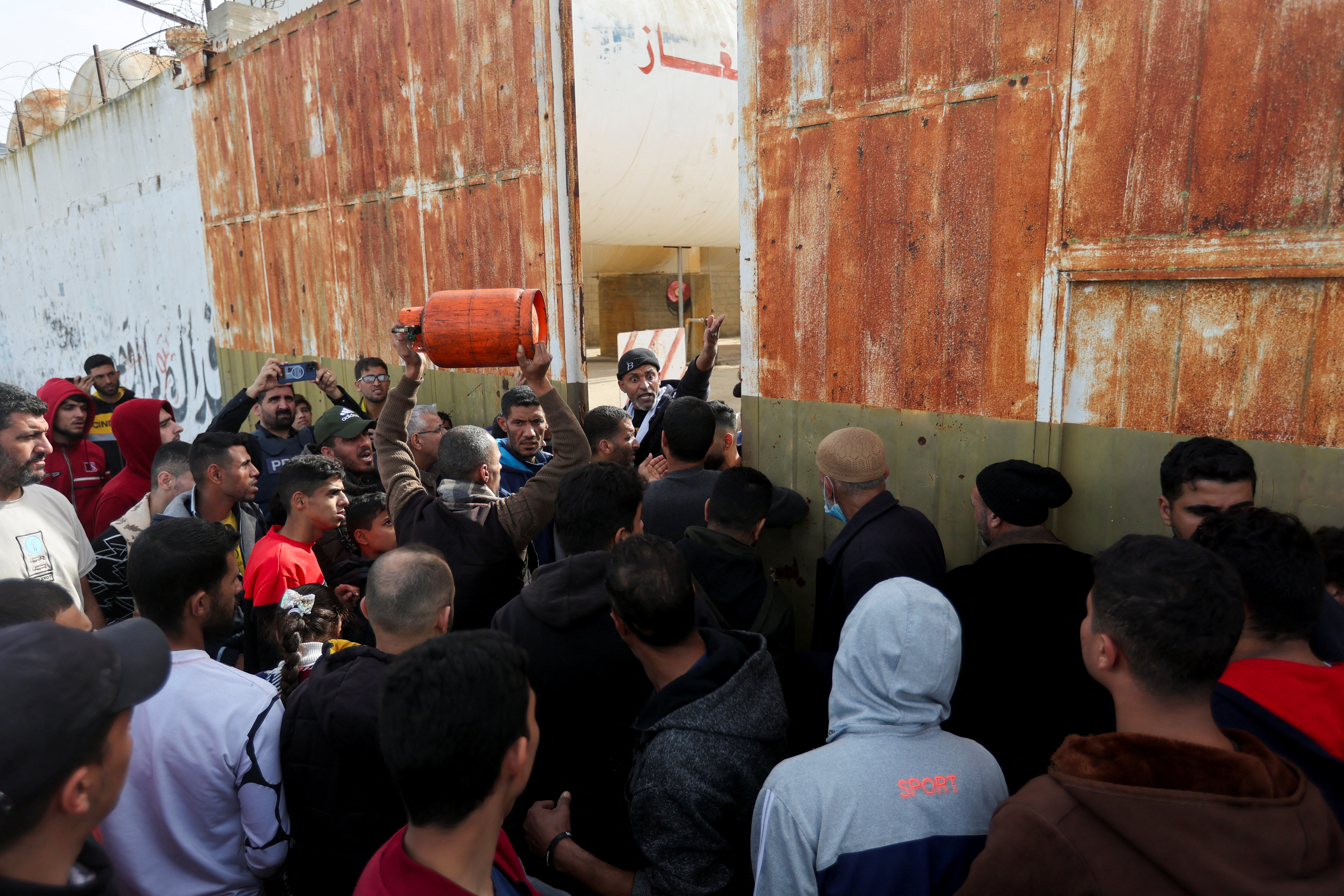 Palestinians gather to buy fuel, amid fuel shortages, during a temporary truce between Hamas and Israel, in Rafah in the southern Gaza Strip November 25