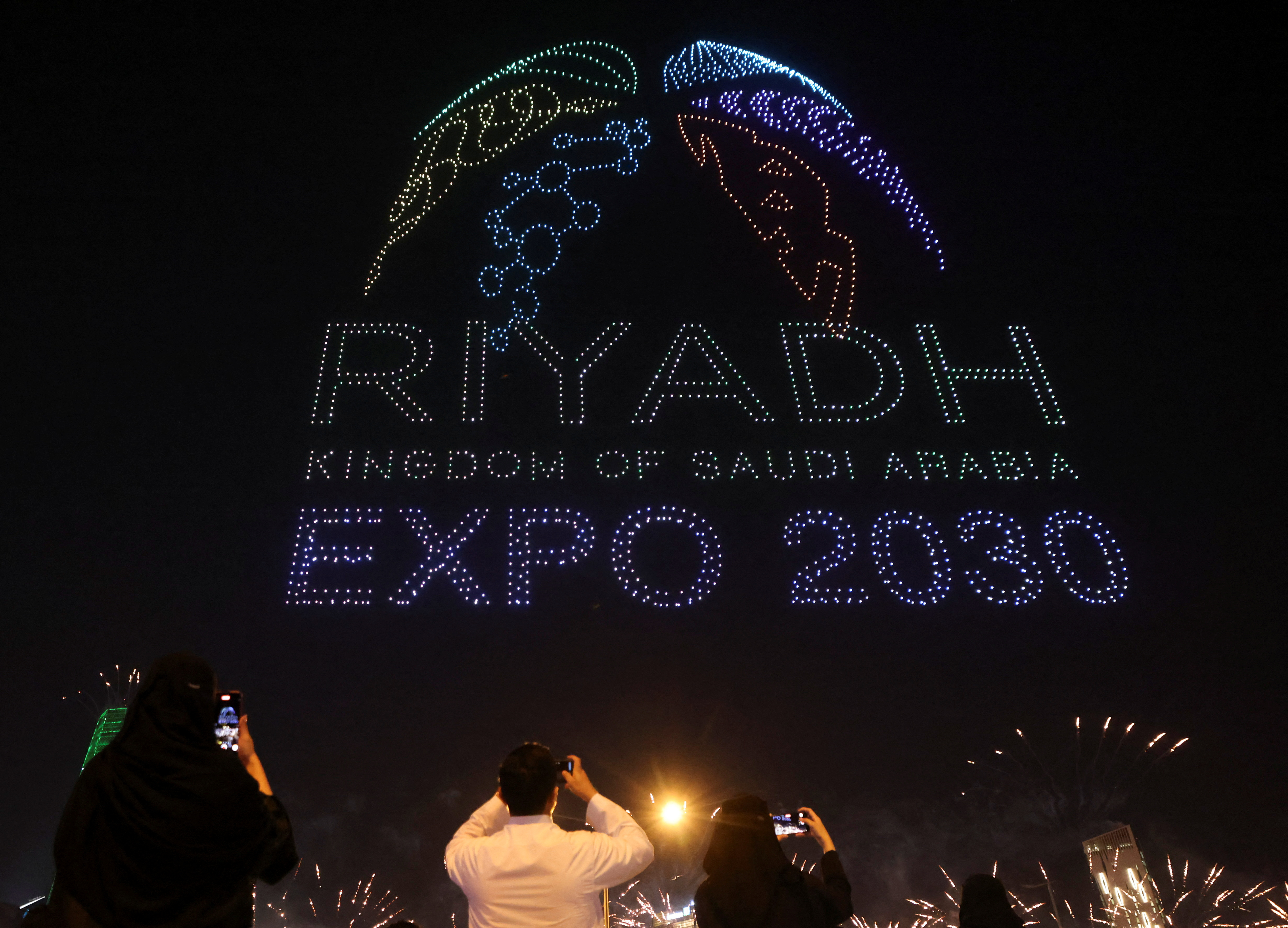 People watch a fireworks show celebrating Saudi Arabia's successful bid to host the 2030 world fair