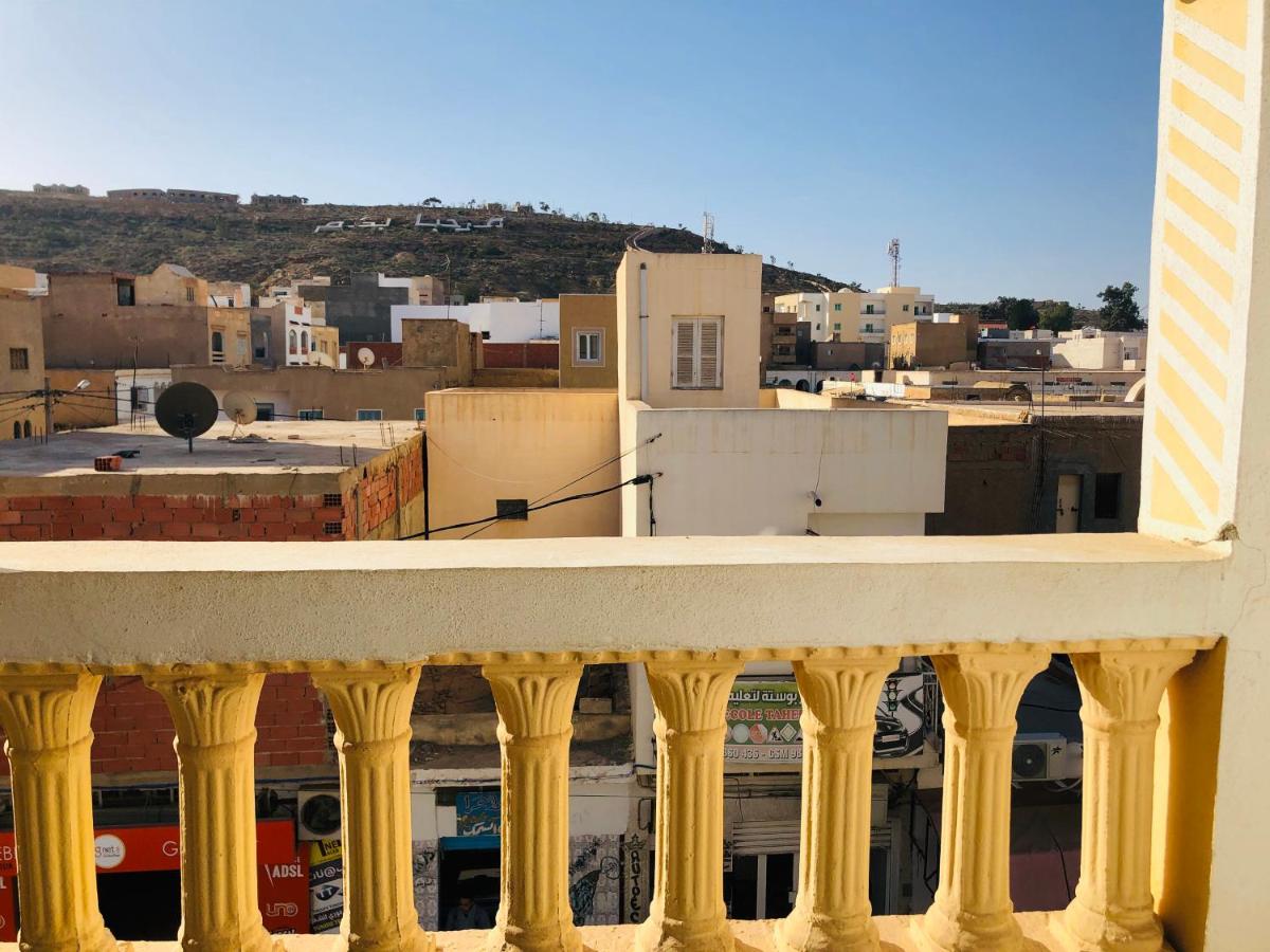 A photo of the view in a balcony with buildings and a mountain.