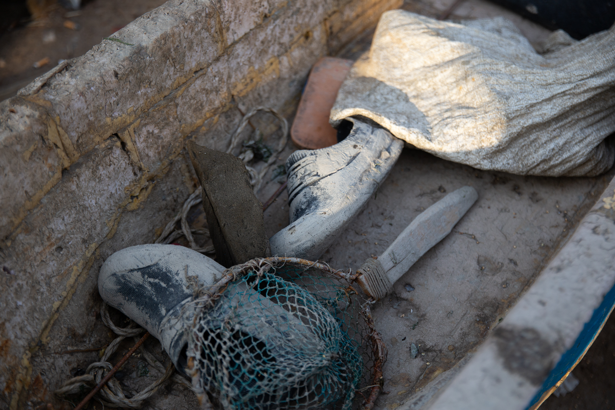 A photo of a boat with shoes and a net inside it.