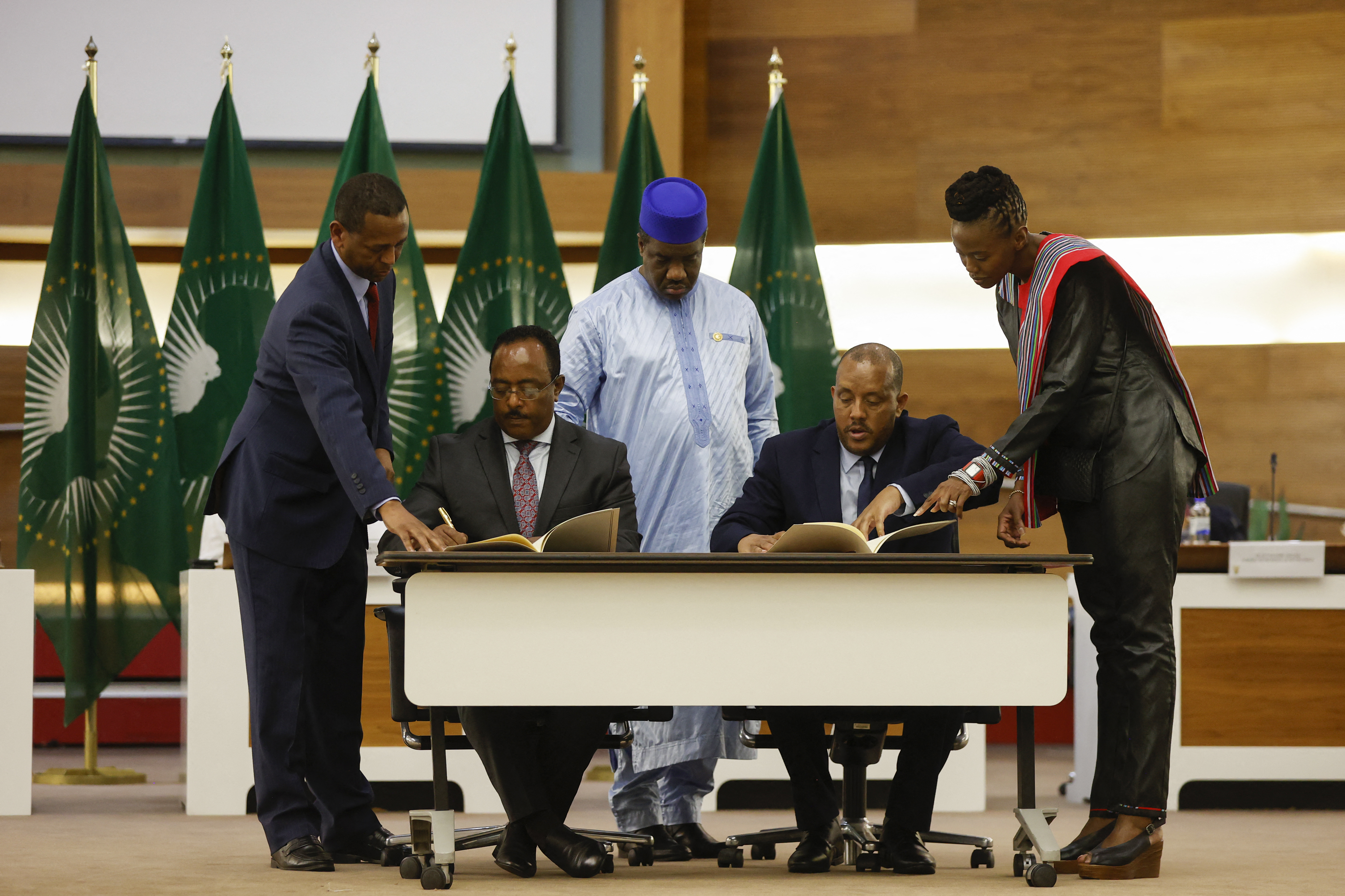Redwan Hussein (2nd L), Representative of the Ethiopian government, and Getachew Reda (2nd R), Representative of the Tigray People's Liberation Front (TPLF), sign a peace agreement between the two parties during a press conference regarding the African Union-led negotiations to resolve conflict in Ethiopia at the Department of International Relations and Cooperation (DIRCO) offices in Pretoria.