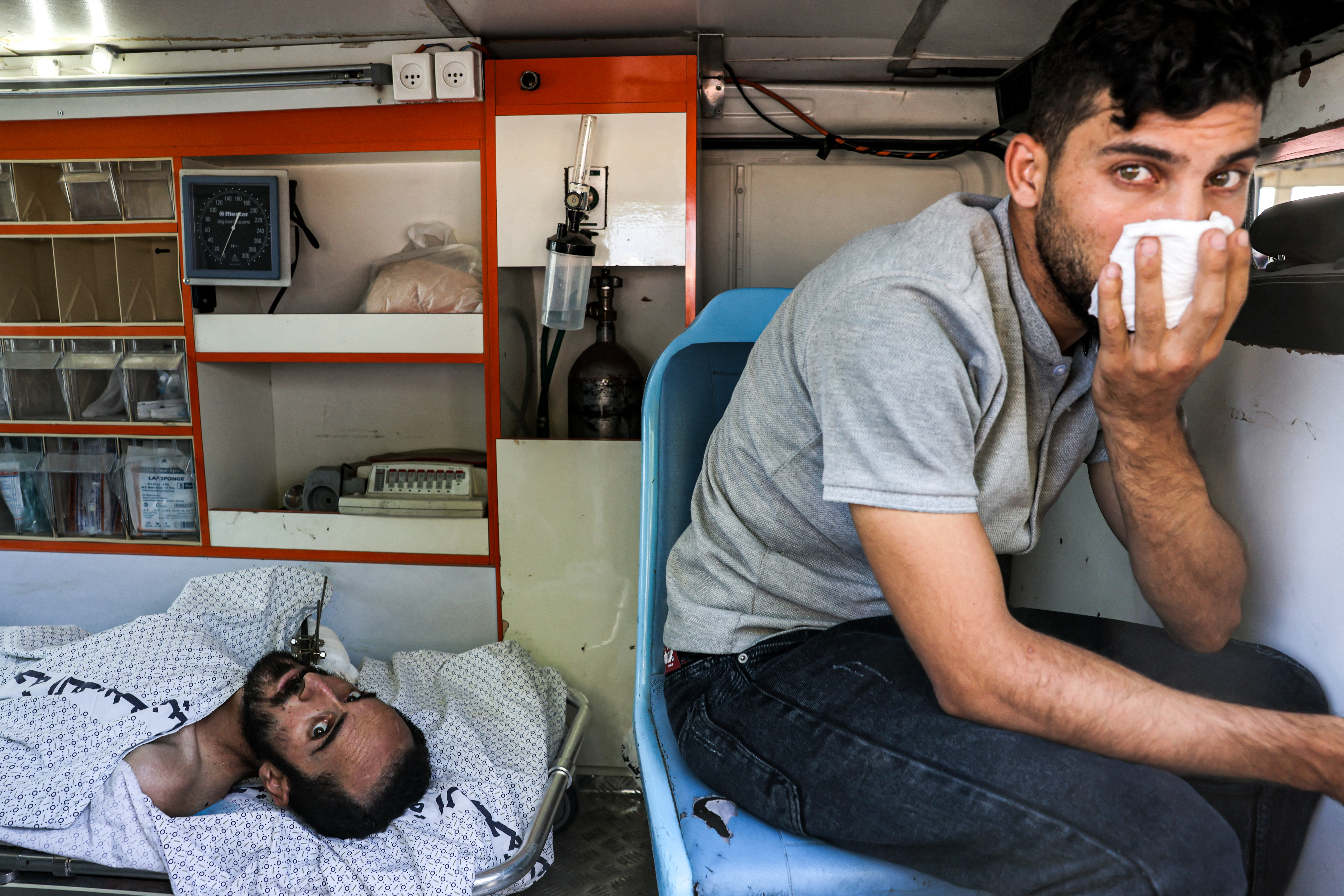 An injured man lies inside an ambulance waiting at the Rafah border crossing in the southern Gaza Strip before receiving medical care in Egypt on November 1, 2023