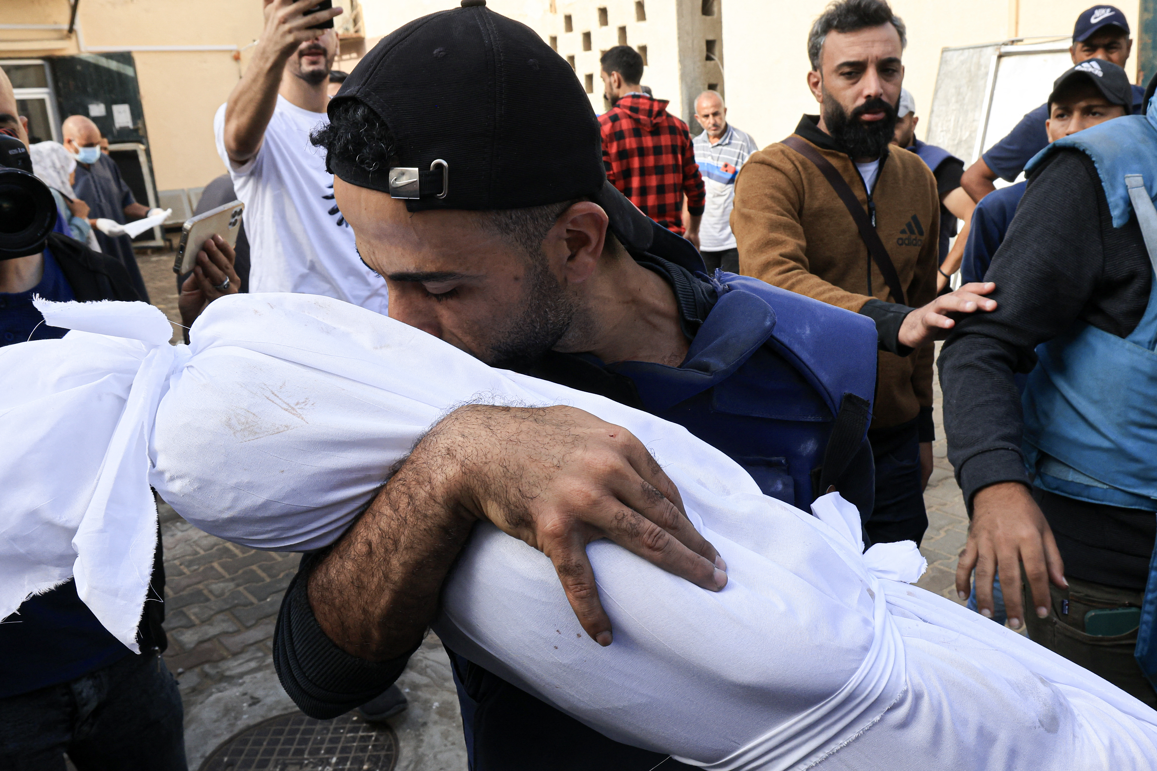 Palestinian cameraman Mohammed Alaloul holds the shrouded body of one of his children killed in an Israeli strike on the Al-Maghazi refugee camp in Deir Balah in the central Gaza Strip.