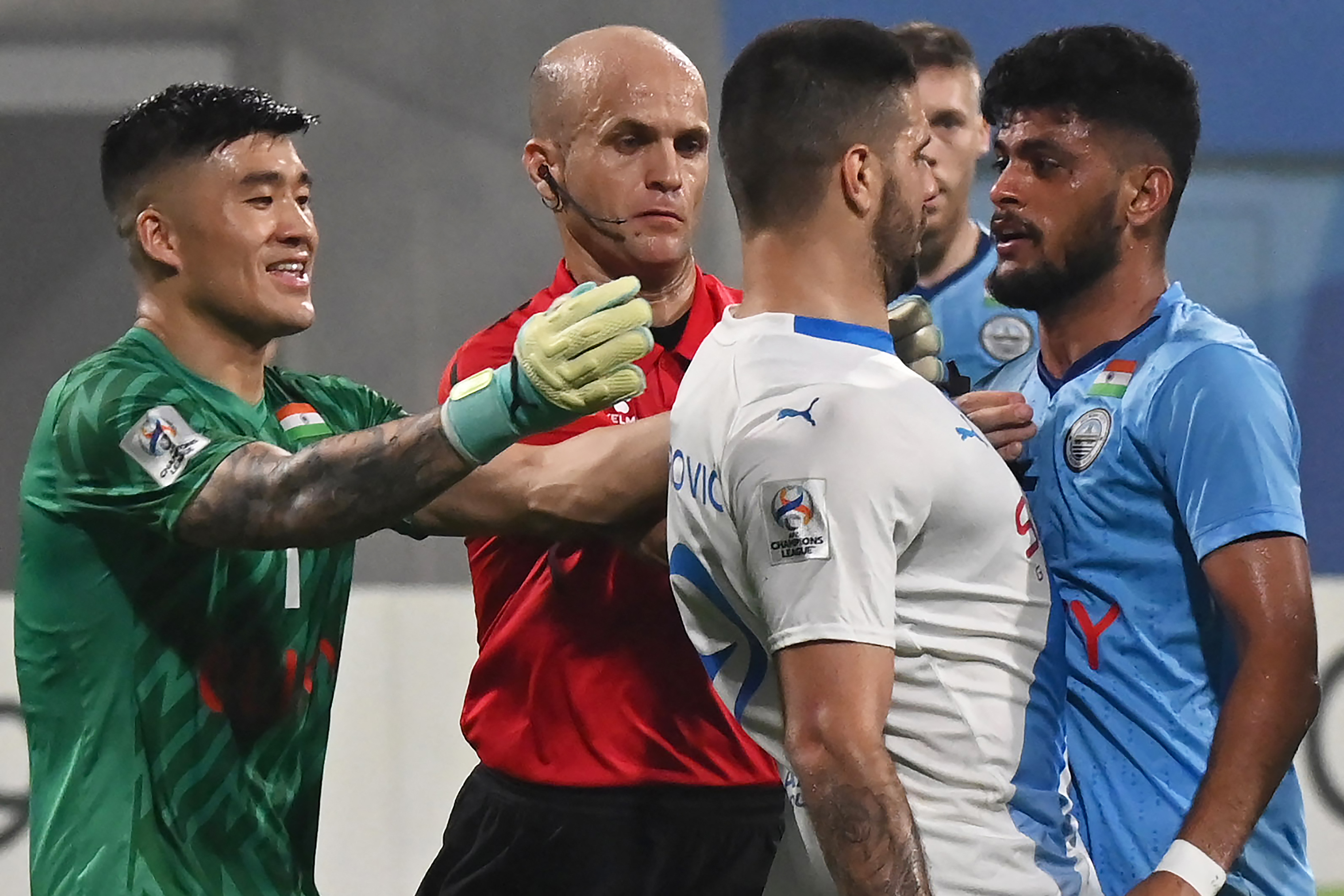 Al-Hilal SFC's forward Aleksandar Mitrovic (C) and Mumbai City FC's goalkeeper Phurba Tempa Lachenpa (L) tussel during the AFC Champions League 2023/24 Group D football match between India's Mumbai City FC and Saudi Arabias Al-Hilal SFC at the D.Y. Patil stadium in Navi Mumbai on November 6, 2023. (Photo by AFP)