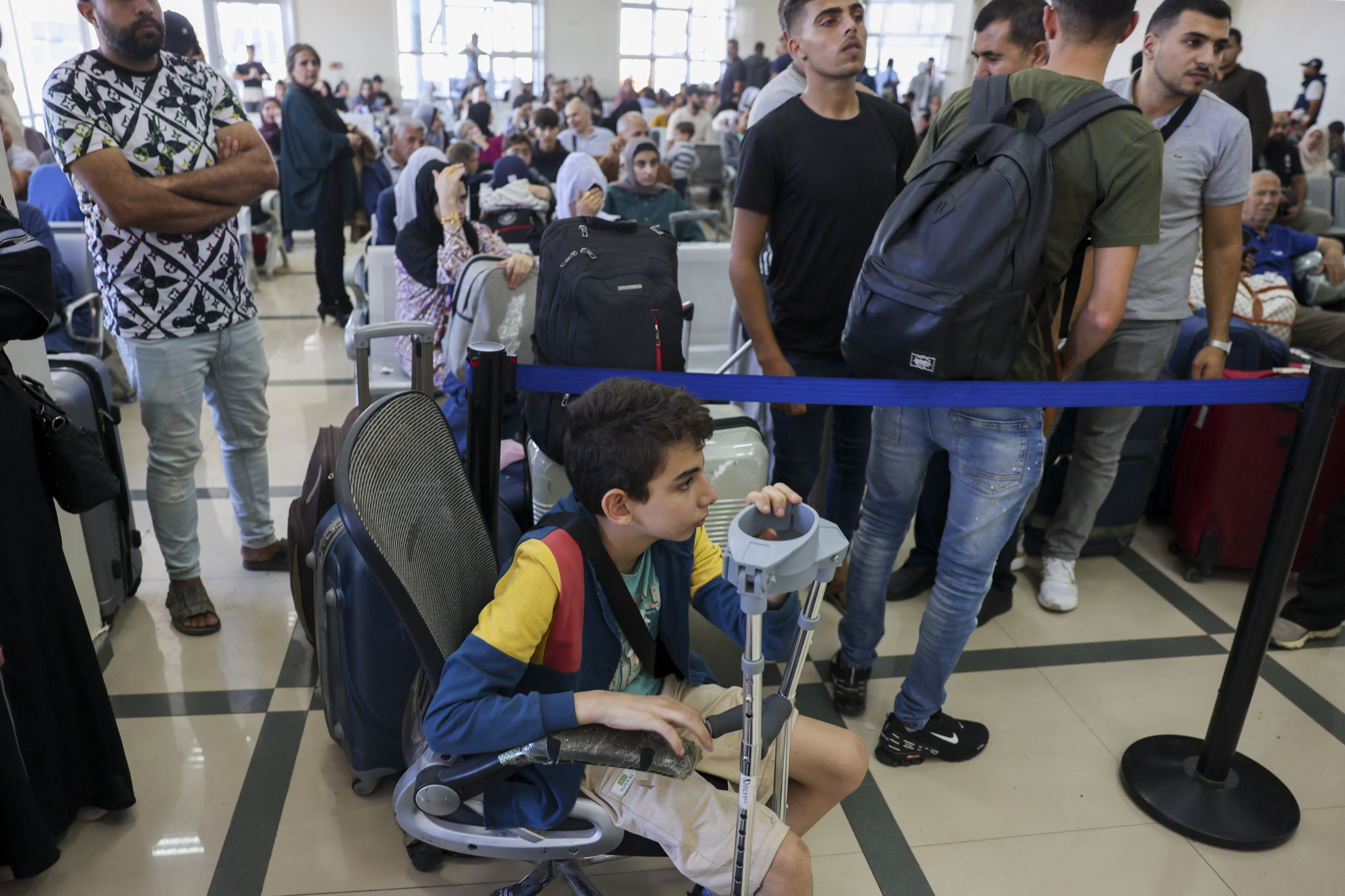 Palestinian dual nationals and foreigners wait to cross the Rafah border crossing with Egypt, in the southern Gaza Strip, on November 7, 2023, amid the ongoing battles between Irael and the militant group Hamas
