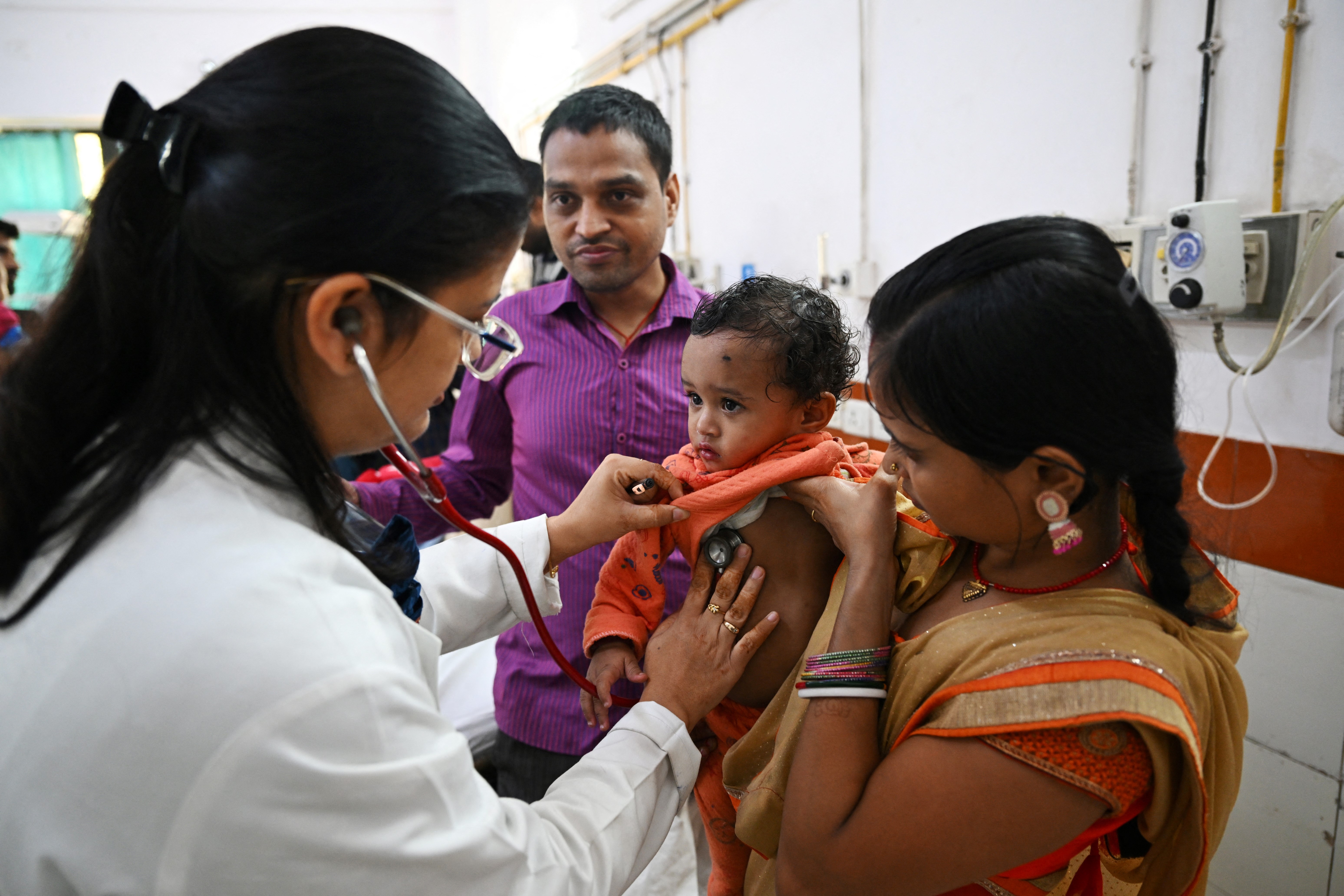 In this picture taken on November 7, 2023, Pediatric Pulmonologist Dr. Dhulika Dhingra (L) auscultates a child with breathing difficulties at the emergency ward of the government-run Chacha Nehru Bal Chikitsalaya children hospital in New Delhi.