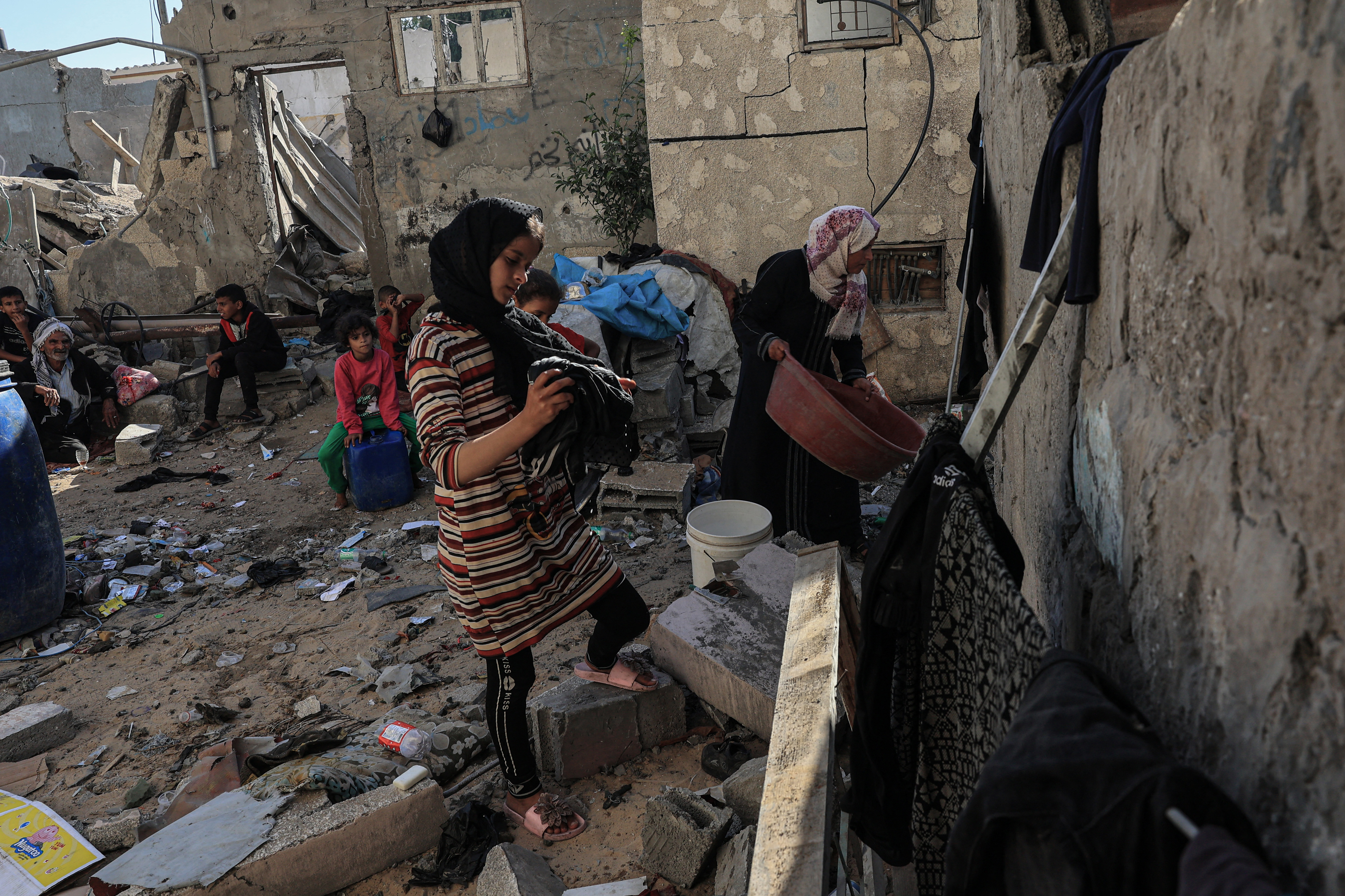 Amal al-Robayaa (R), washes clothes