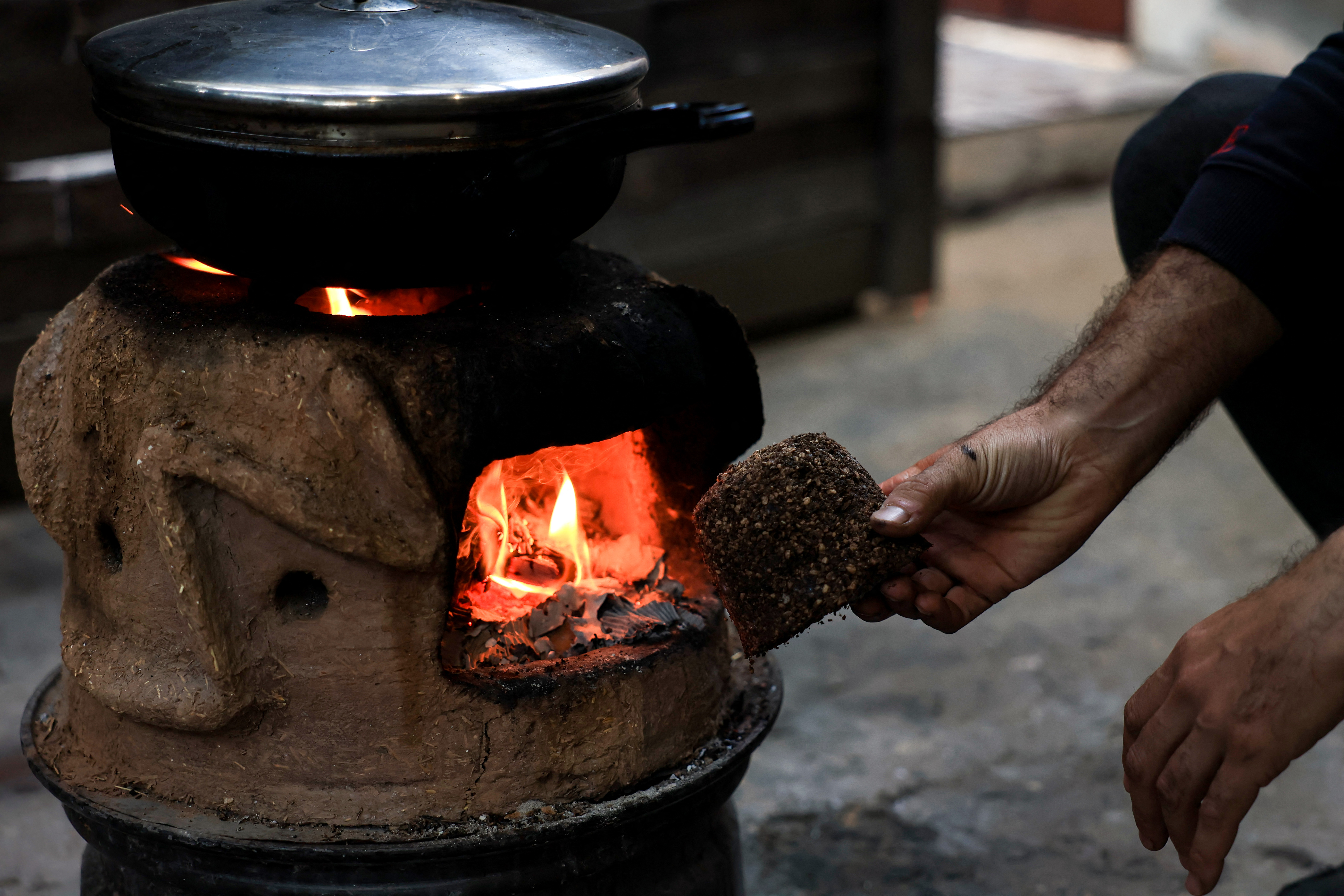 A Palestinian man manufactures a mixture of crushed olive pits to be used as fire starter amid fuel shortages in Rafah, in the southern Gaza Strip.