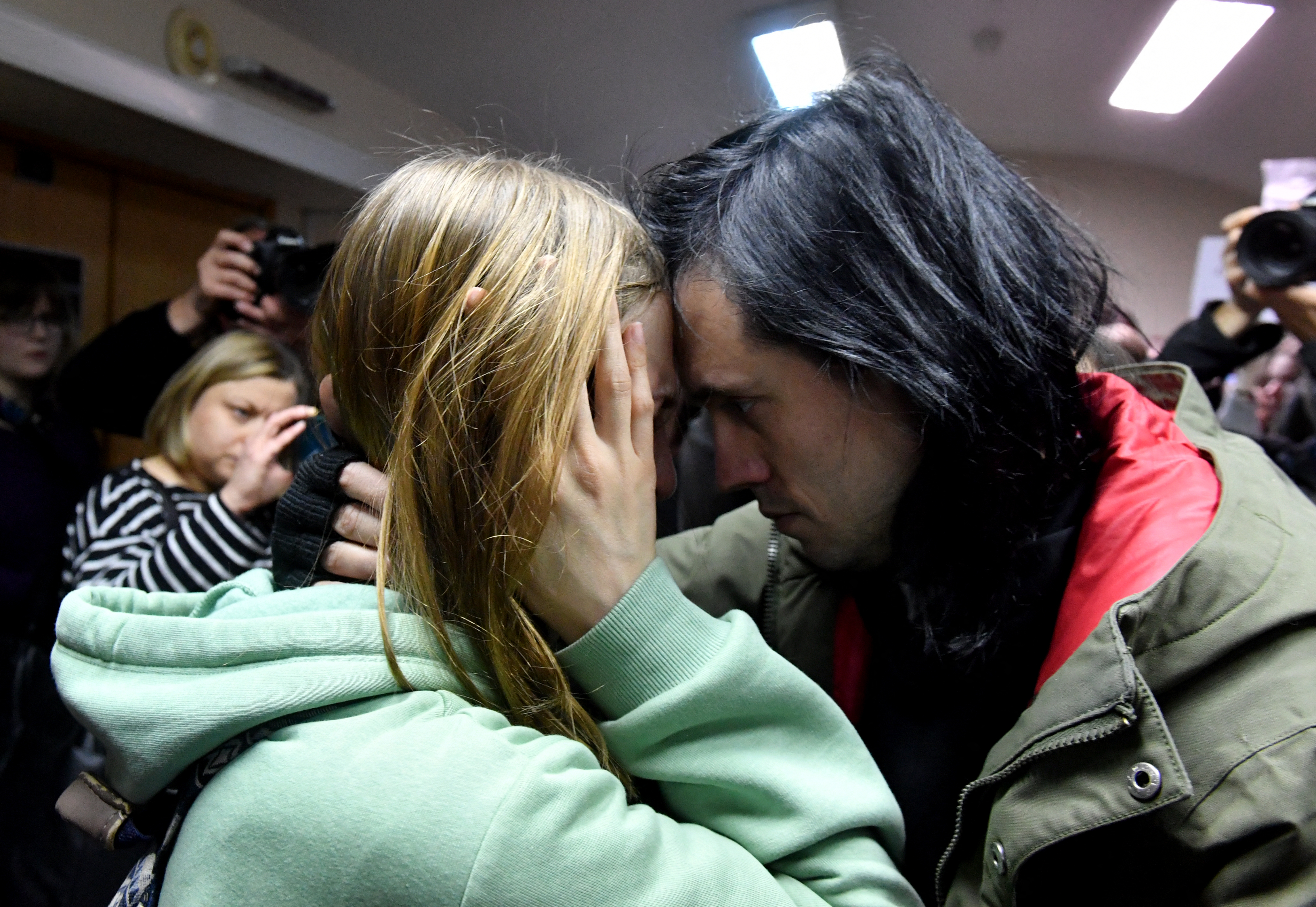Friends of Alexandra Skochilenko hug each other after the verdict.