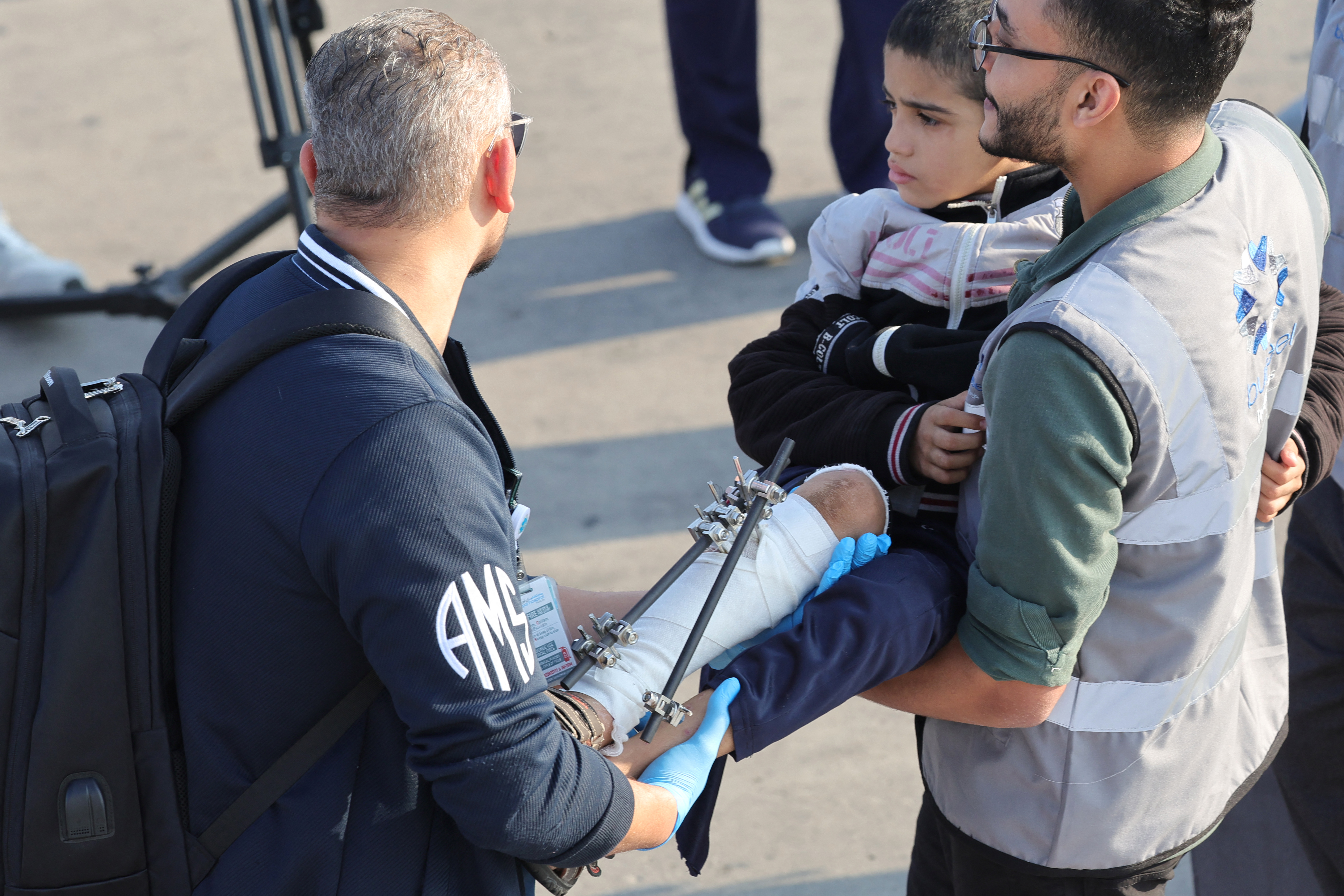 Volunteers transport a wounded Palestinian child off the plane upon their arrival in Abu Dhabi on November 18, 2023, after being evacuated from Gaza as part of a humanitarian mission organised by the United Arab Emirates