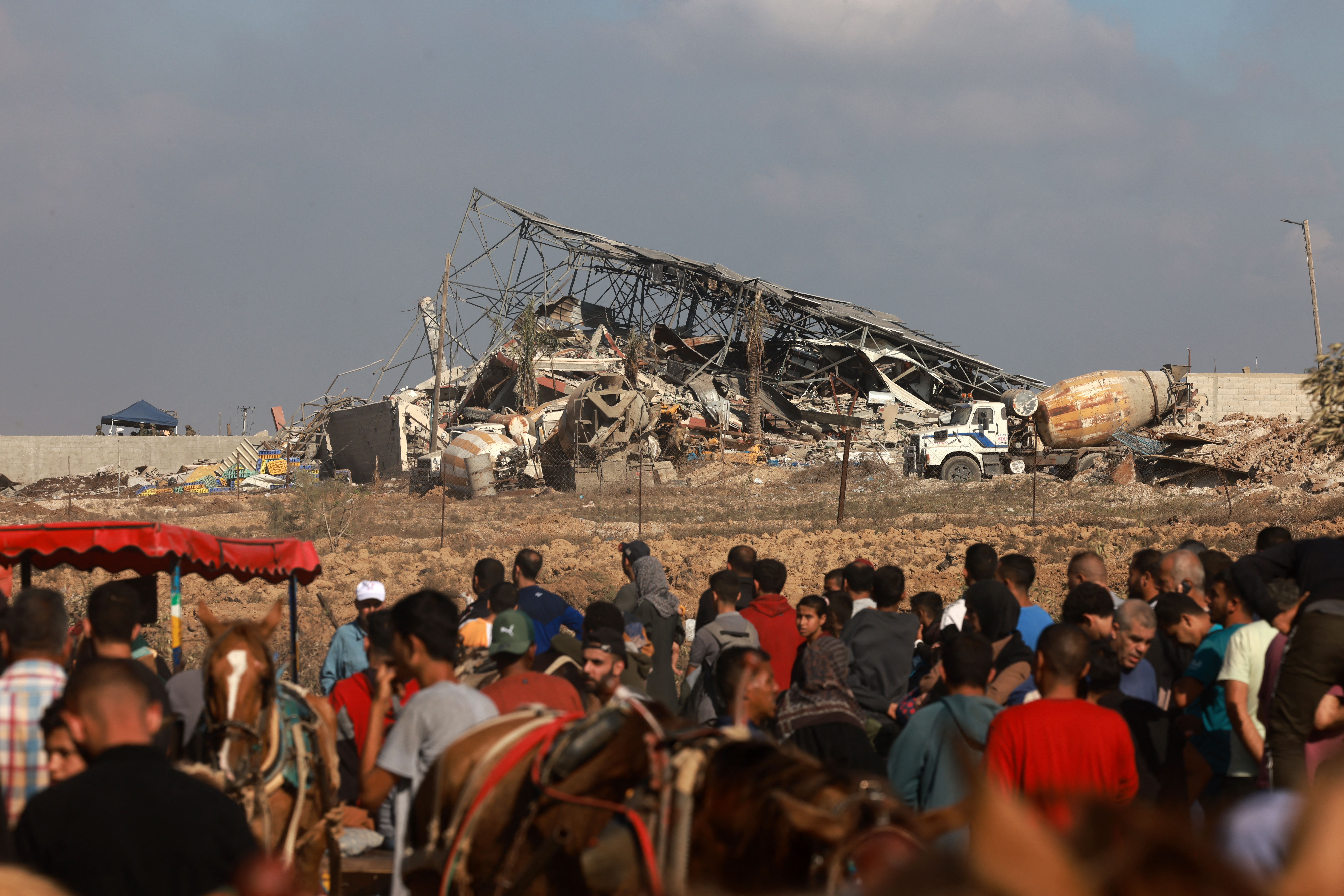 Israeli soldiers watch from their position as Palestinians fleeing Gaza City and other parts of northern Gaza walk down a road leading to the southern areas of the enclave.