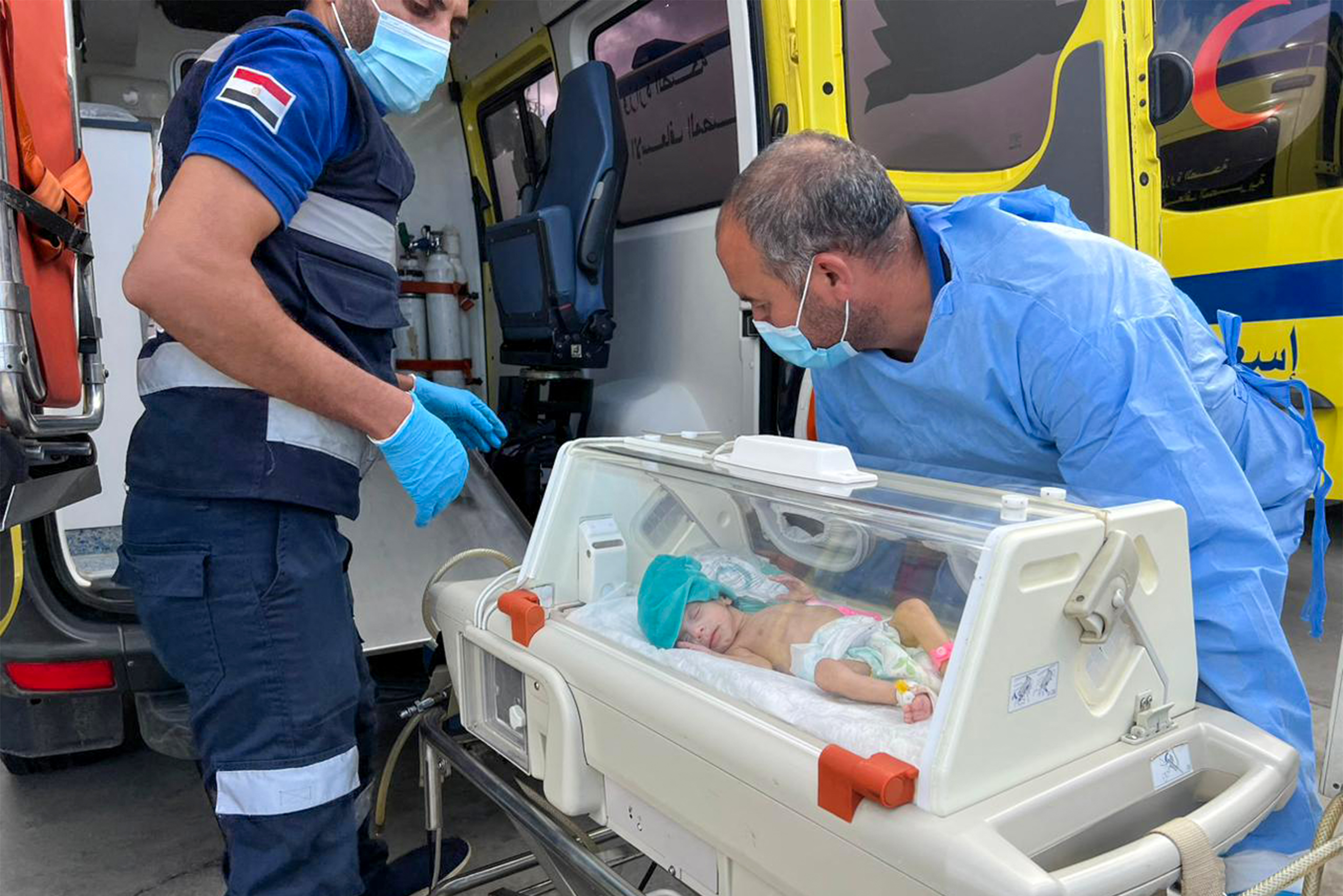 Medics transfer premature Palestinian babies evacuated from Gaza to ambulances on the Egyptian side of the Rafah border