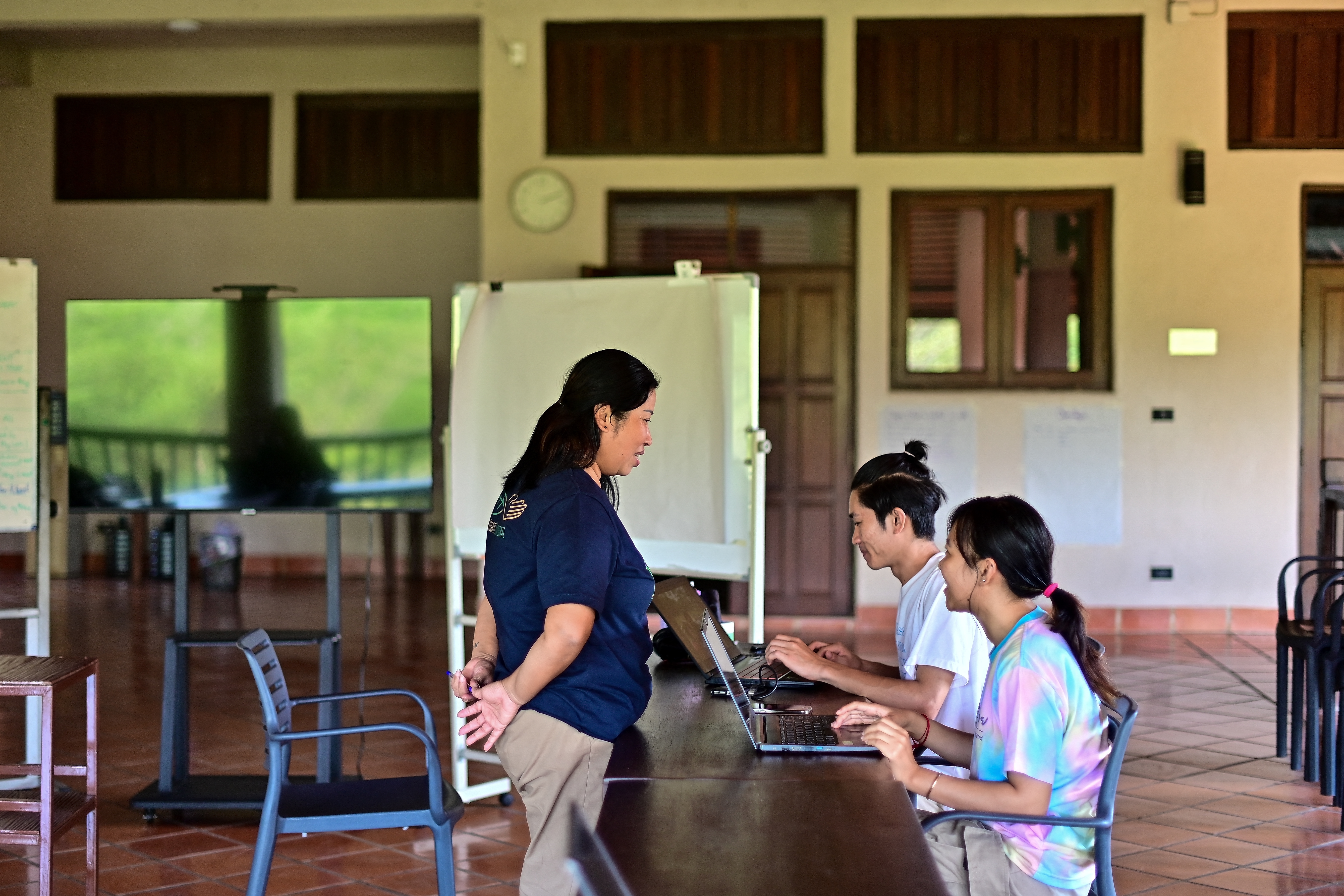 This photograph taken on November 21, 2023 shows school leader and alumna Khin Nanda (L) talking to Kino Khanhthamaly (C), an environmentalist working in Laos, and San Somanear (R), an environmentalist from Cambodia, at the EarthRights School in Chiang Mai.