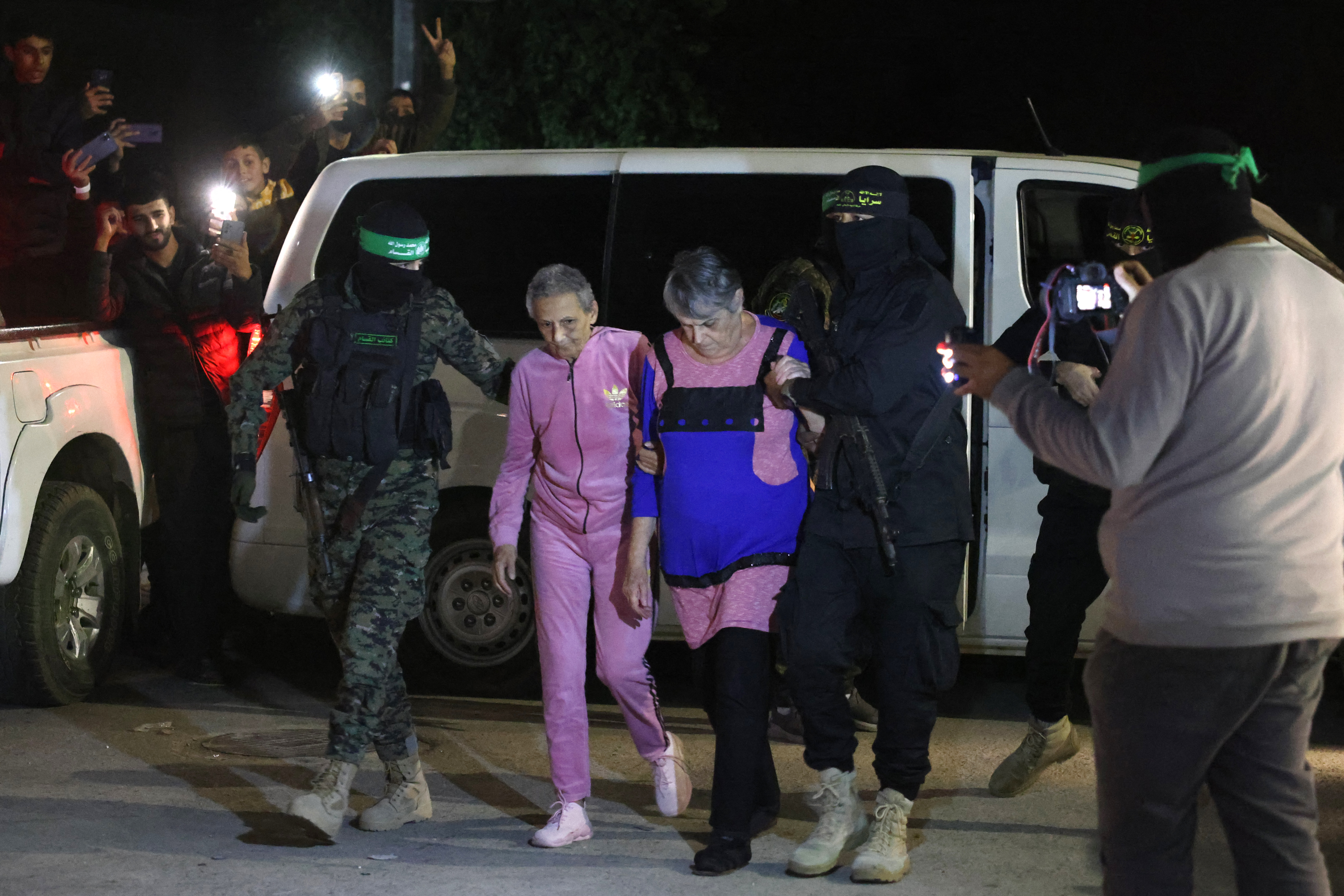Hamas and Islamic Jihad fighters accompany newly released hostages before handing them over to the Red Cross in Rafah, in the southern Gaza Strip on November 28