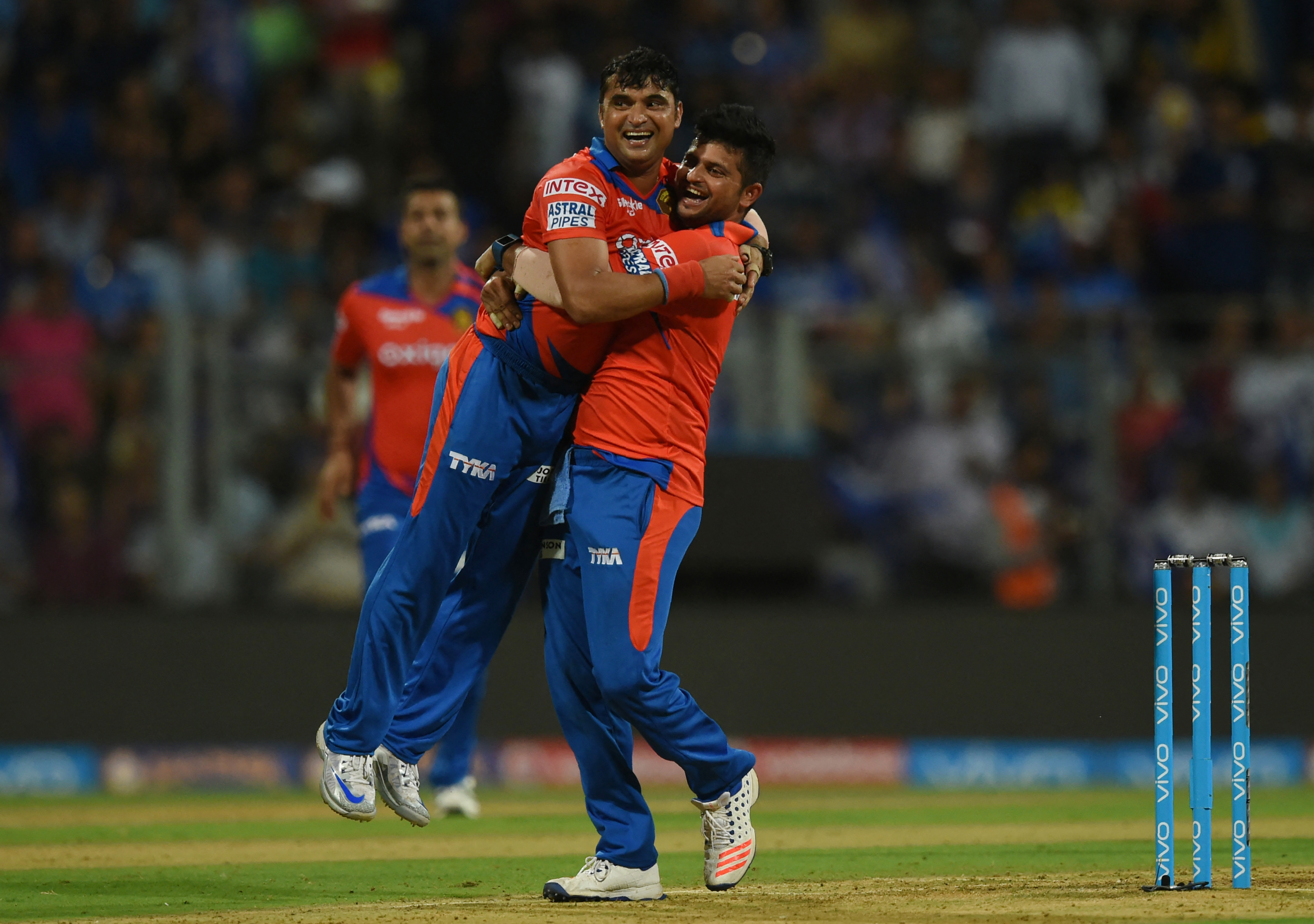Gujarat Lions captain Suresh Raina (R) lifts teammate Pravin Tambe