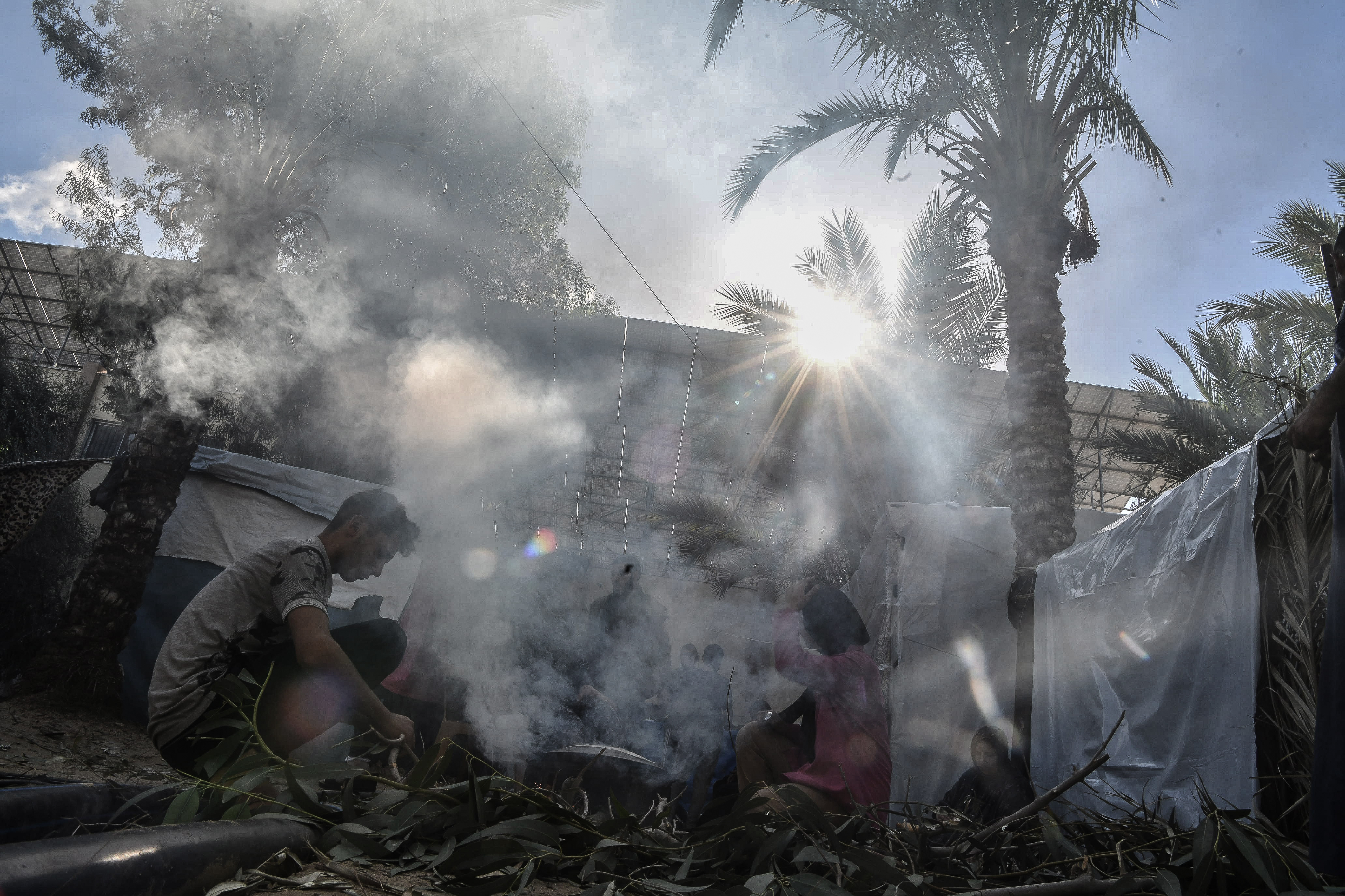 Volunteers prepare food for distribution to Palestinian families who displaced to the area around Nasser Hospital as Palestinians try to continue their daily lives amid Israeli attacks in Khan Yunis, Gaza.