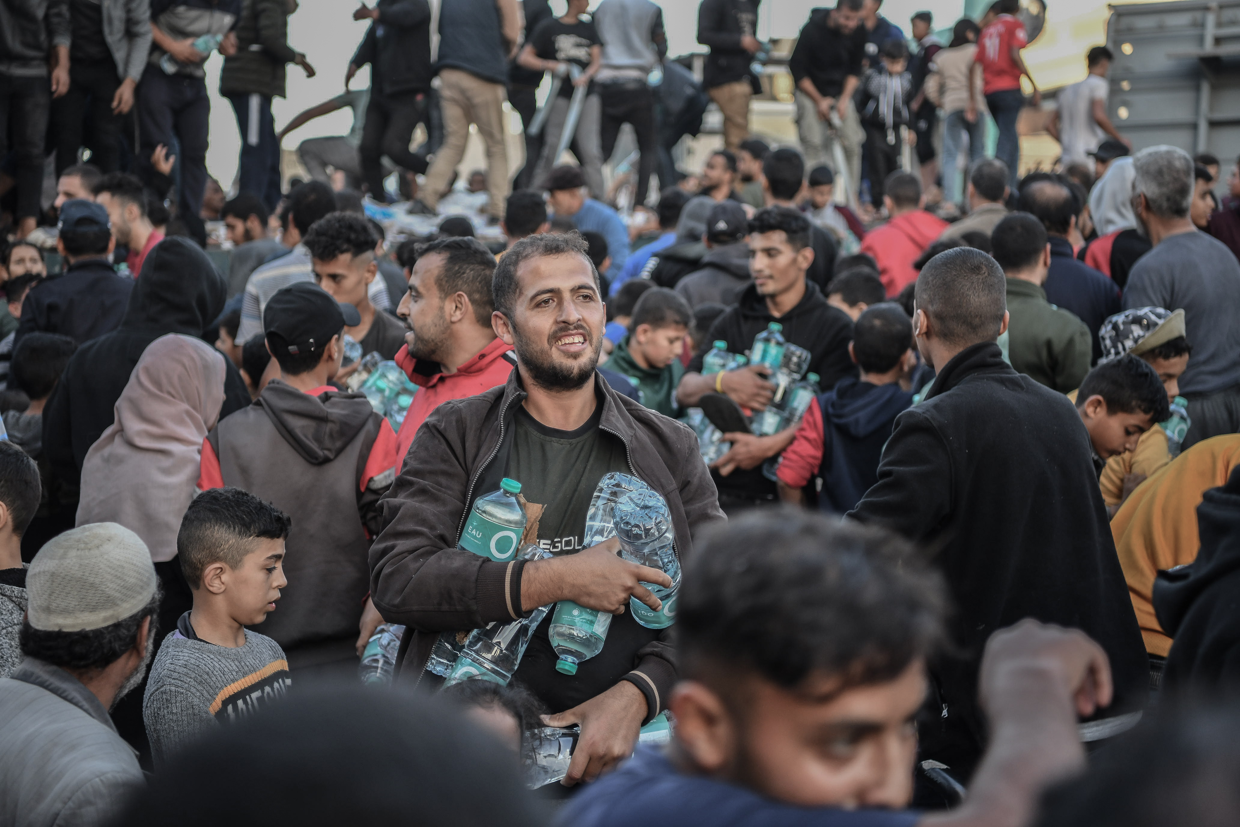 Palestinians flock around a truck carrying bottles of drinking water sent by the United Nations Children's Fund (UNICEF) as the civilians experience water and food shortages due to Israeli attacks in Khan Yunis, Gaza.