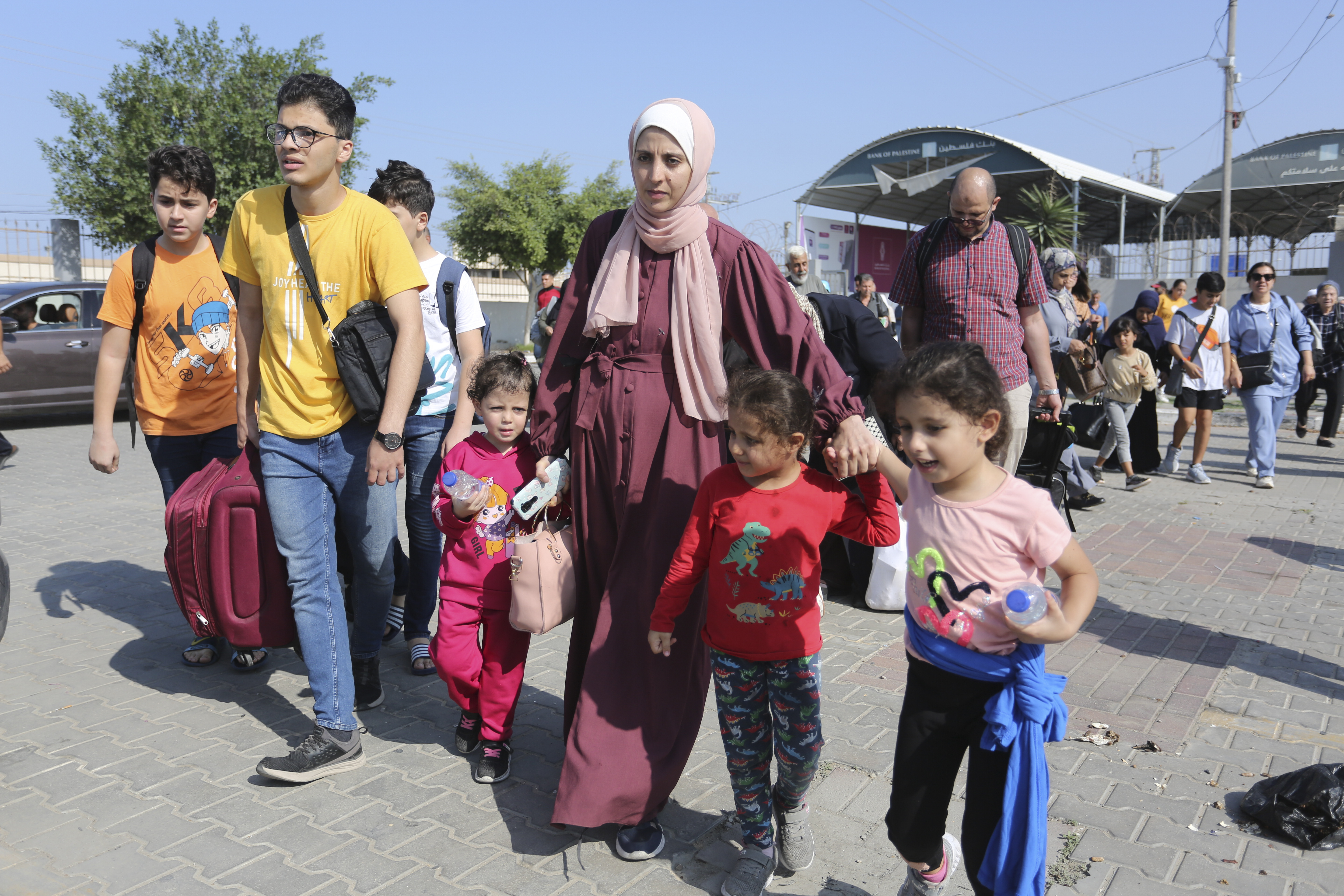 Palestinians cross to the Egyptian side of the border with the Gaza
