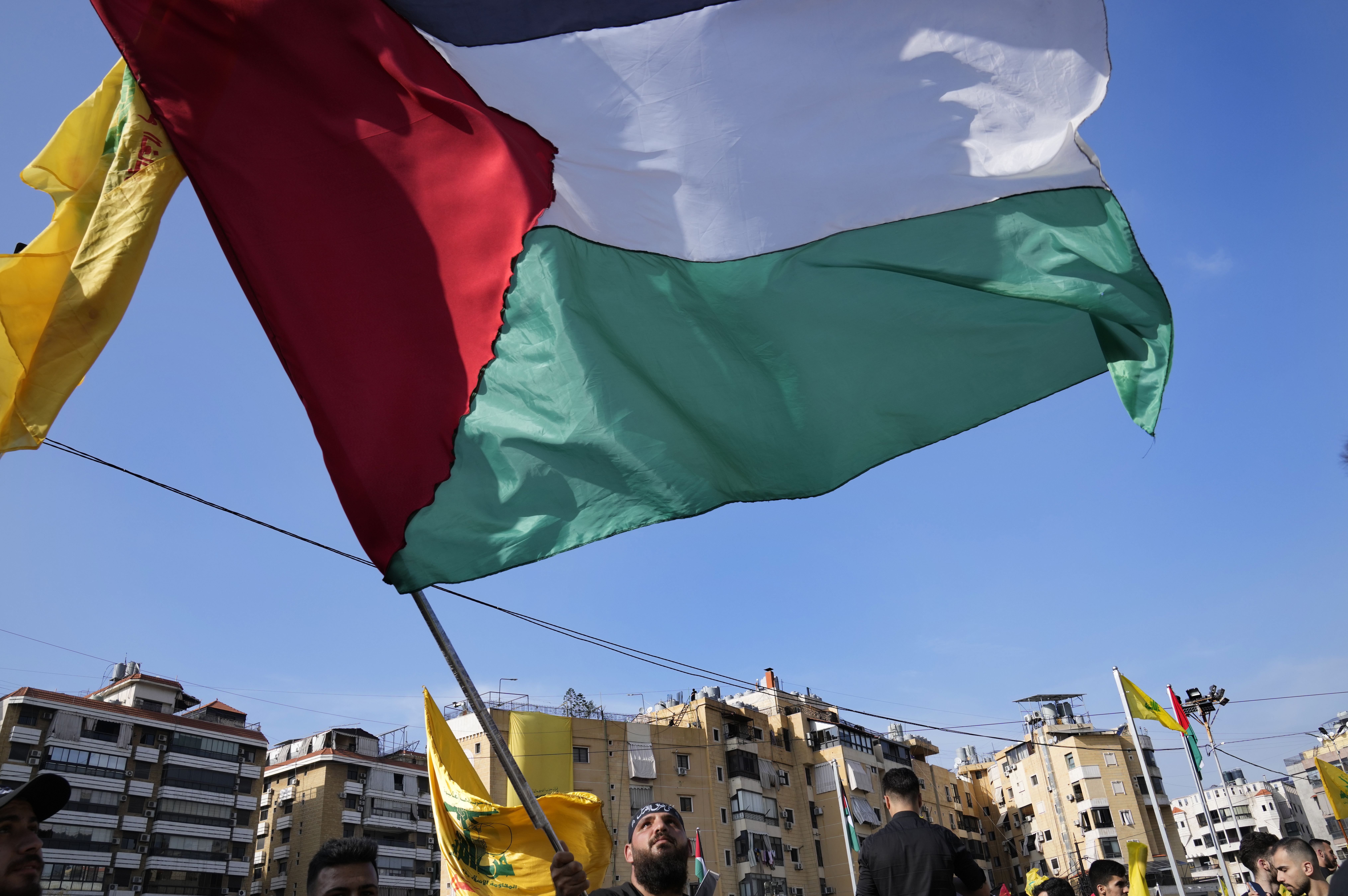 A supporter of the Iranian-backed Hezbollah group waves a Palestinian flag, as he waits the speech of Hezbollah leader Sayyed Hassan Nasrallah, during a rally to commemorate Hezbollah fighters who were killed in South Lebanon last few weeks while fighting against the Israeli forces, in Beirut, Lebanon.