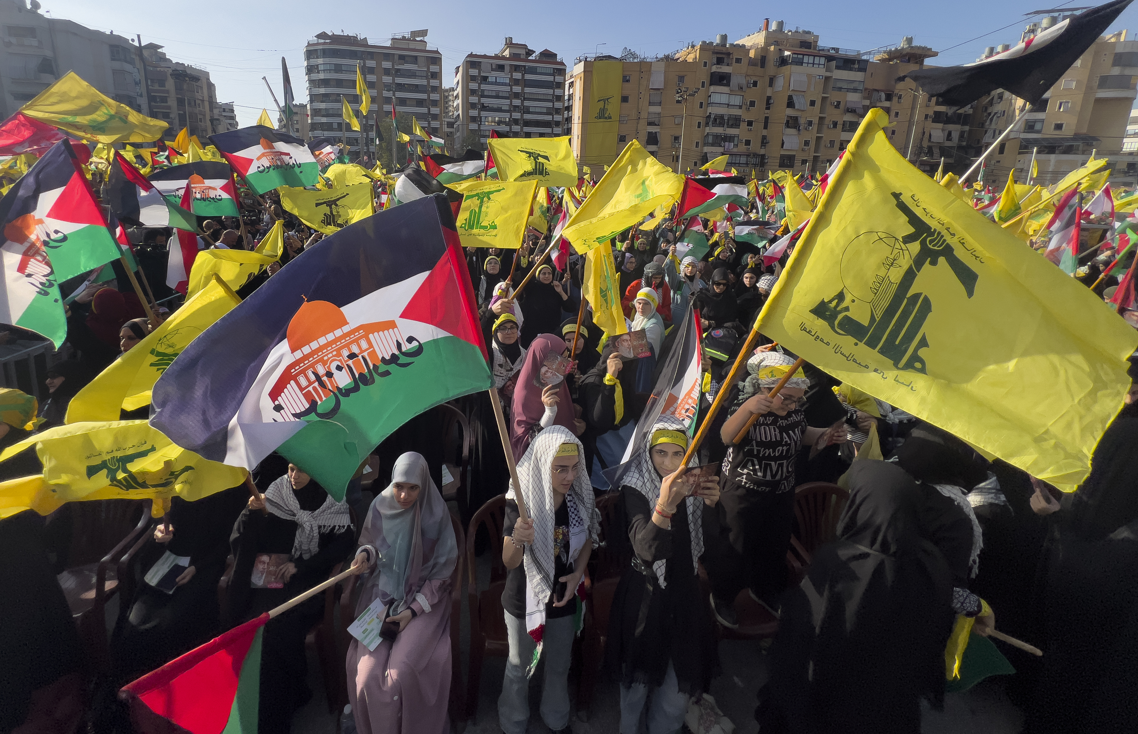 Supporters of the Iranian-backed Hezbollah group wave Palestinian and their group flags, as they wait the speech of Hezbollah leader Sayyed Hassan Nasrallah, during a rally to commemorate Hezbollah fighters who were killed in South Lebanon last few weeks while fighting against the Israeli forces, in Beirut, Lebanon.