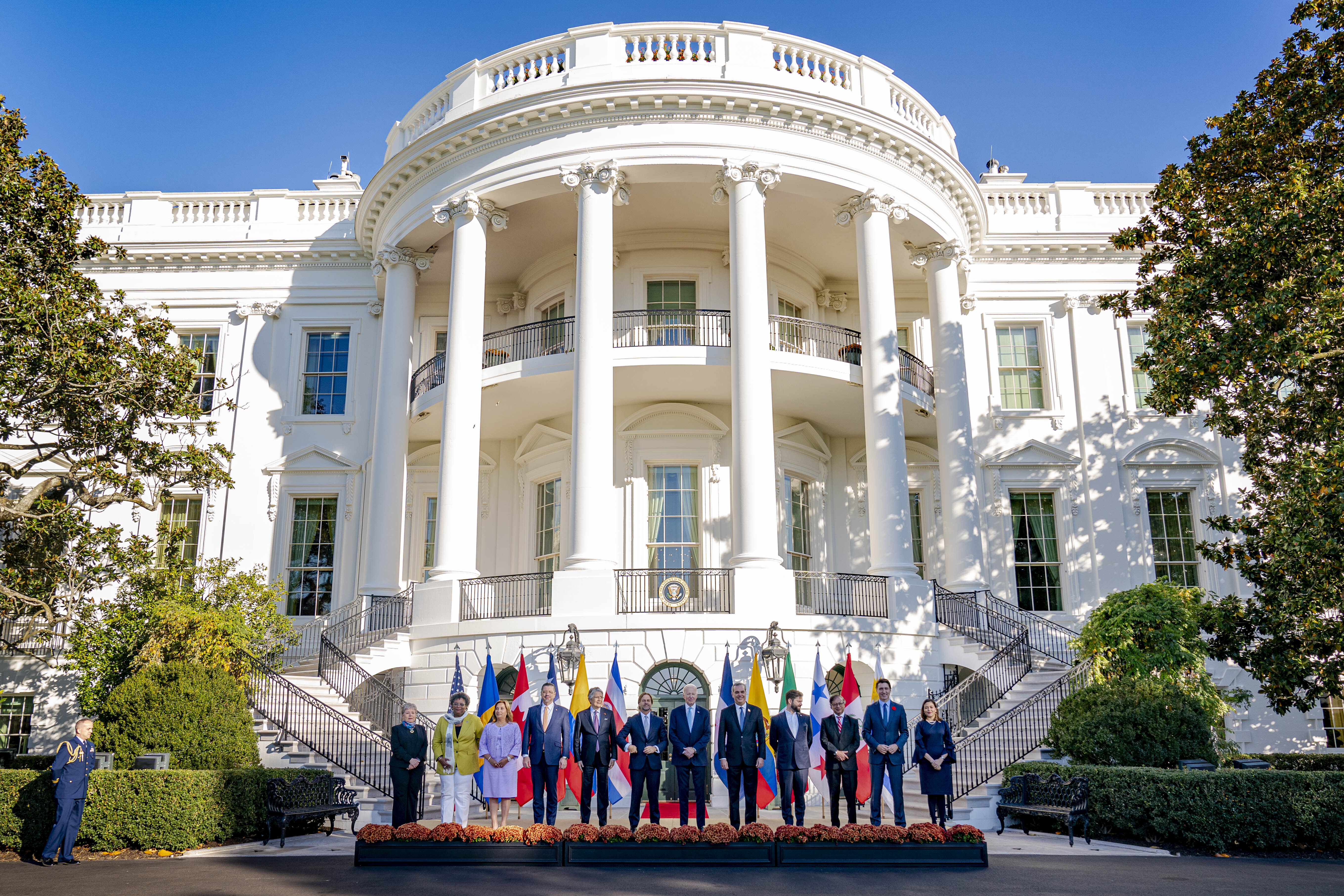 Leaders line up before the portico of the White House for a photo opportunity outdoors.