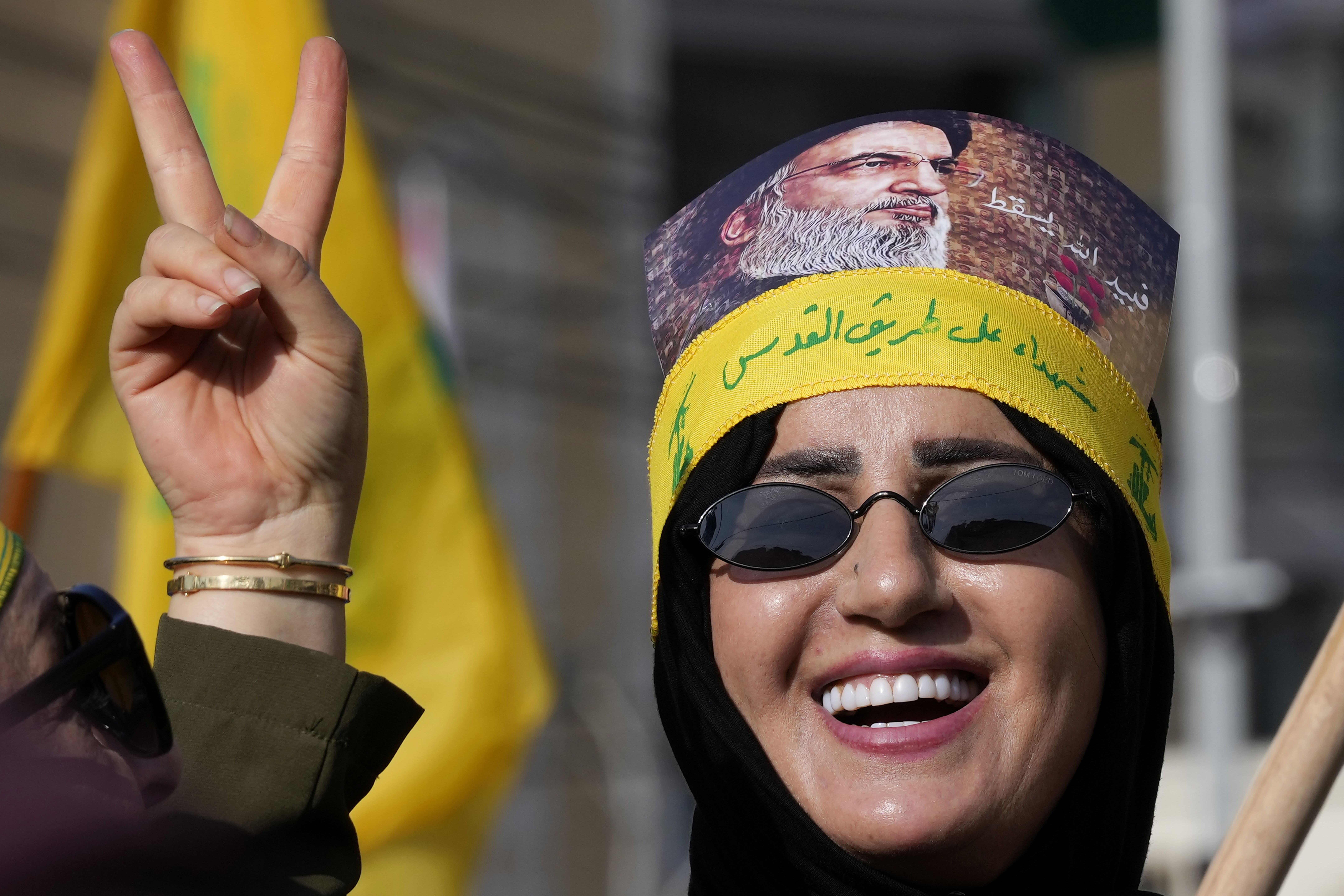 A supporter of the Iranian-backed Hezbollah group flashes victory sign with an Arabic head band that reads:"Martyrs on Jerusalem road," as she waits the speech of Hezbollah leader Sayyed Hassan Nasrallah during a rally to commemorate Hezbollah fighters who were killed in South Lebanon last few weeks while fighting against the Israeli forces, in Beirut, Lebanon.