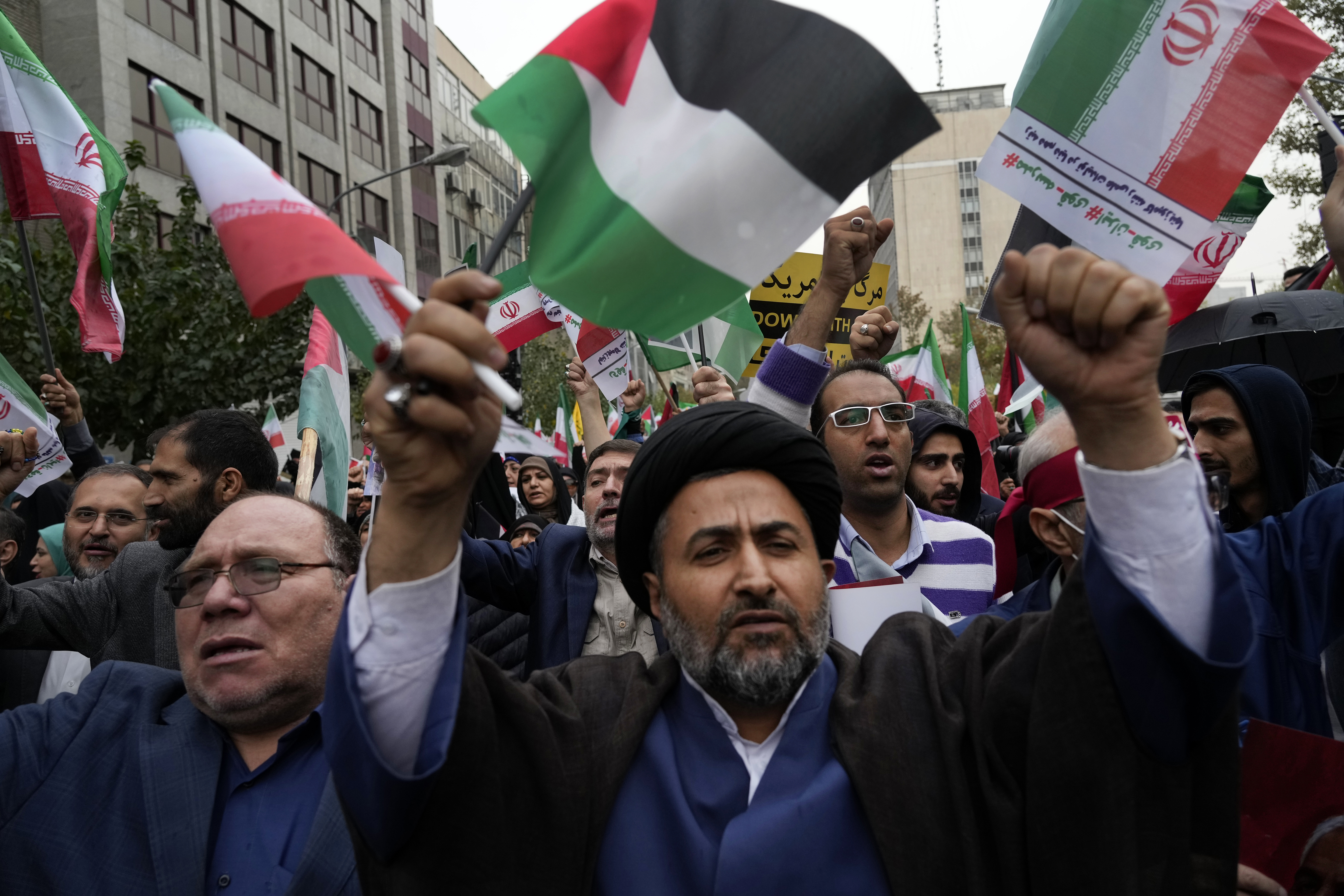 Iranian demonstrators chant slogans as they hold Iranian and Palestinian flags during a rally in front of the former U.S. Embassy in Tehran, Iran.