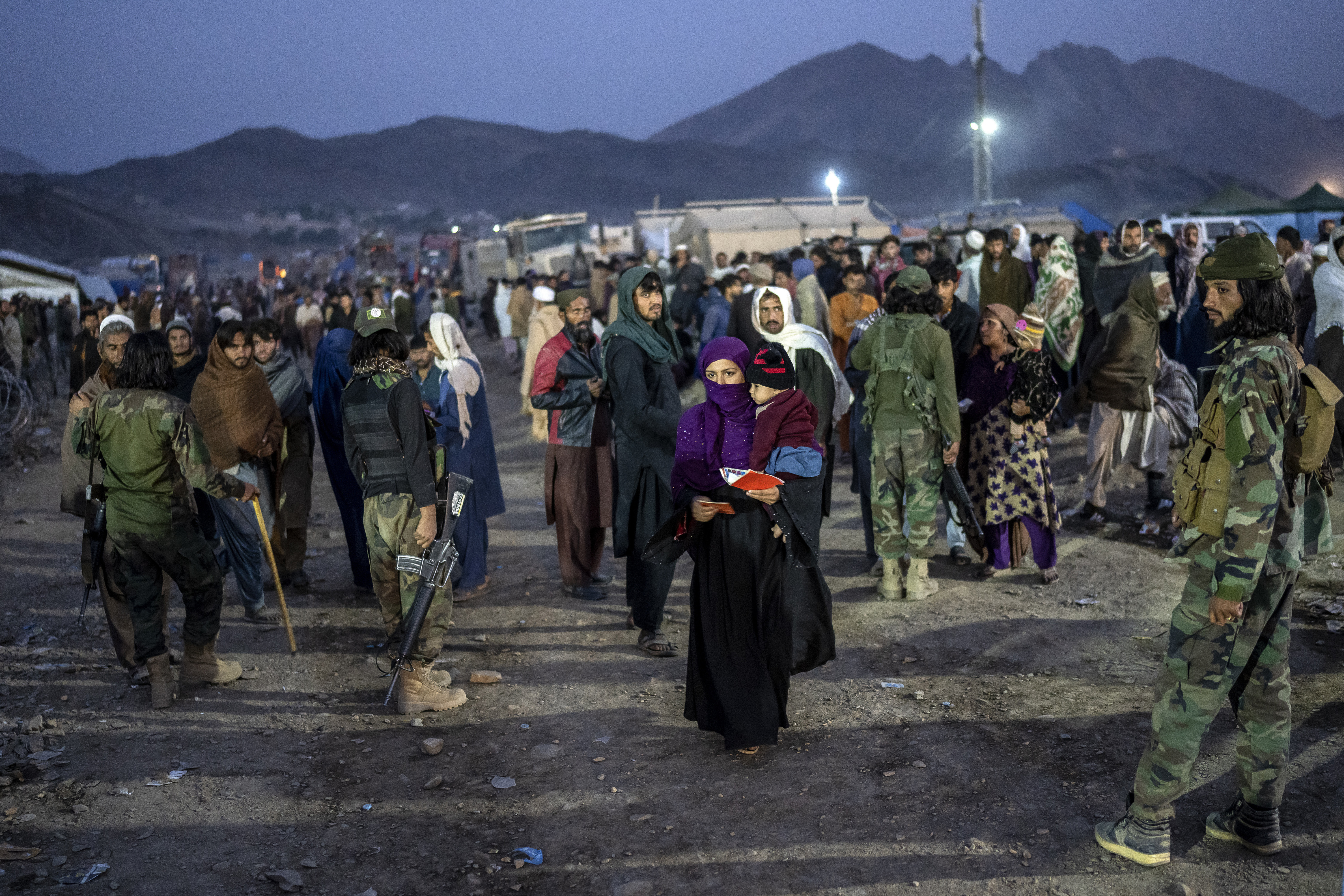 Taliban fighters stand guard as Afghan refugees wait to register in a camp near the Torkham Pakistan-Afghanistan border in Torkham, Afghanistan.