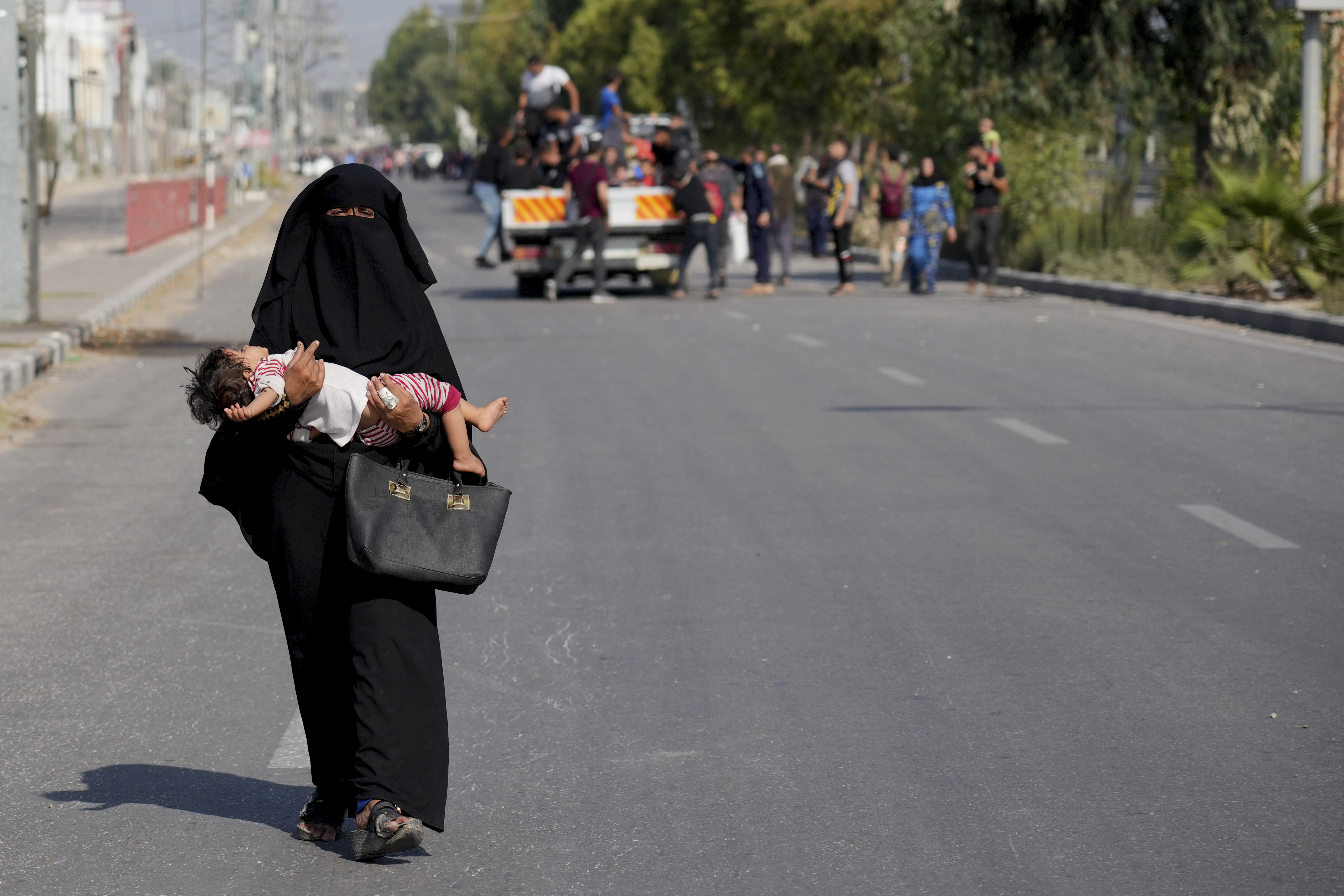 Palestinians flee the southern Gaza Strip on Salah al-Din street in Bureij on Sunday, Nov. 5